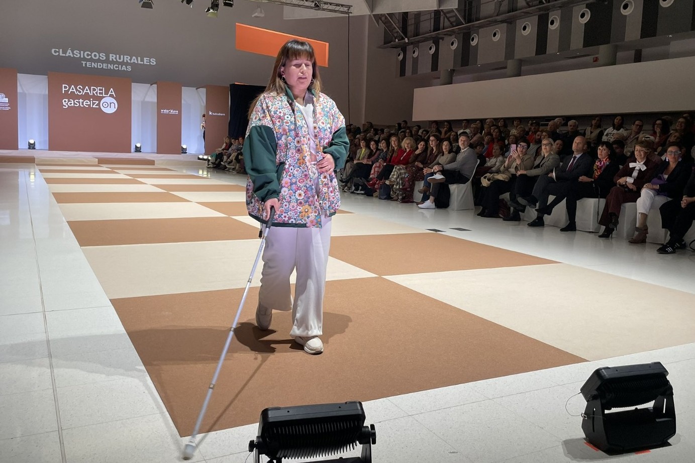 Mariana Senzano desfila, al ritmo de la música y con su bastón blanco, en la pasarela inclusiva Gasteiz-On, en el Palacio Europa de Vitoria