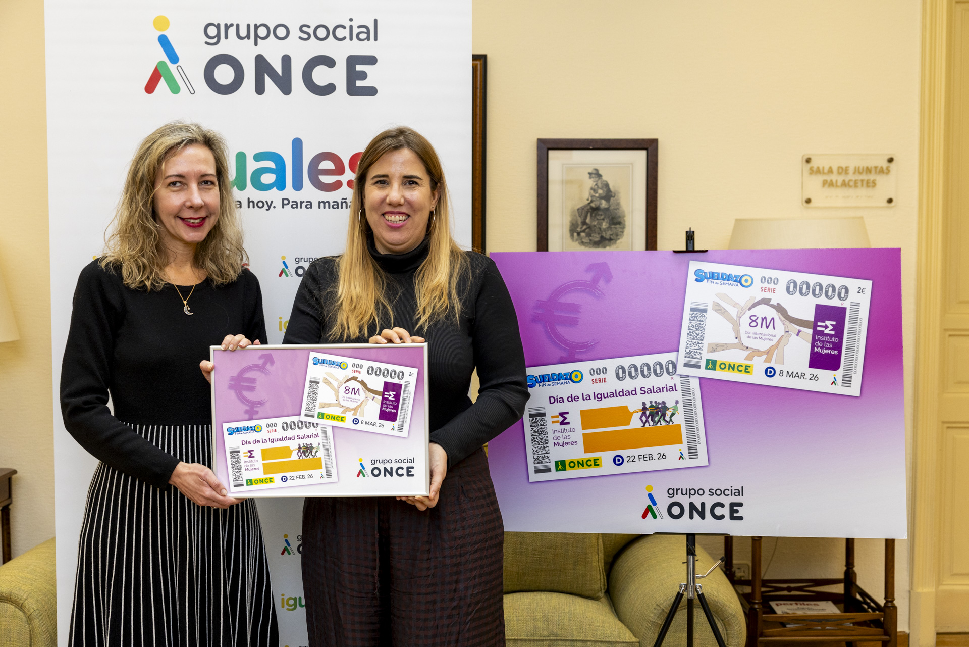 Patricia Sanz y Cristina Hernández, con una lámina enmarcada con ambos cupones