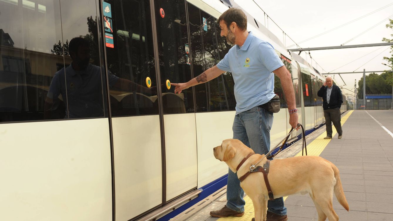 Perro guía junto a su instructor de la FOPG accediendo al interior de un vagón de tren