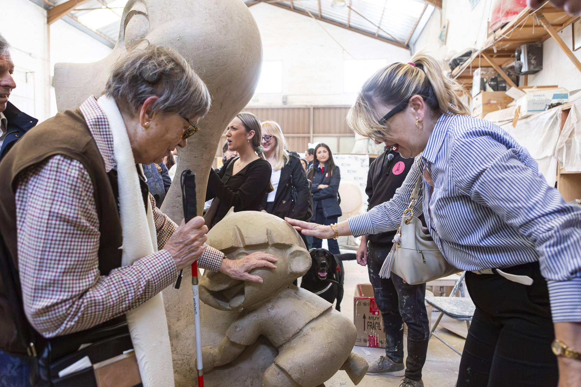 Dos personas sordociegas tocan unos de los ninots