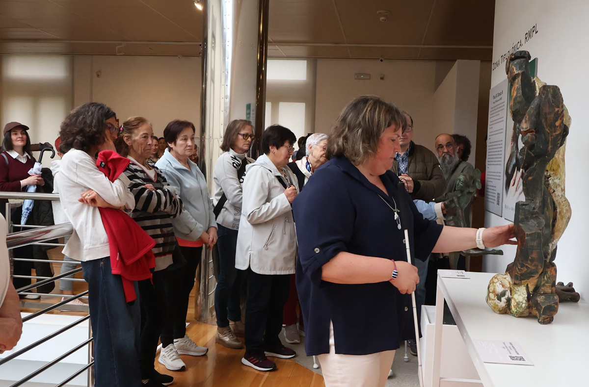 Ángeles Miguélez tocando una de las esculturas expuestas
