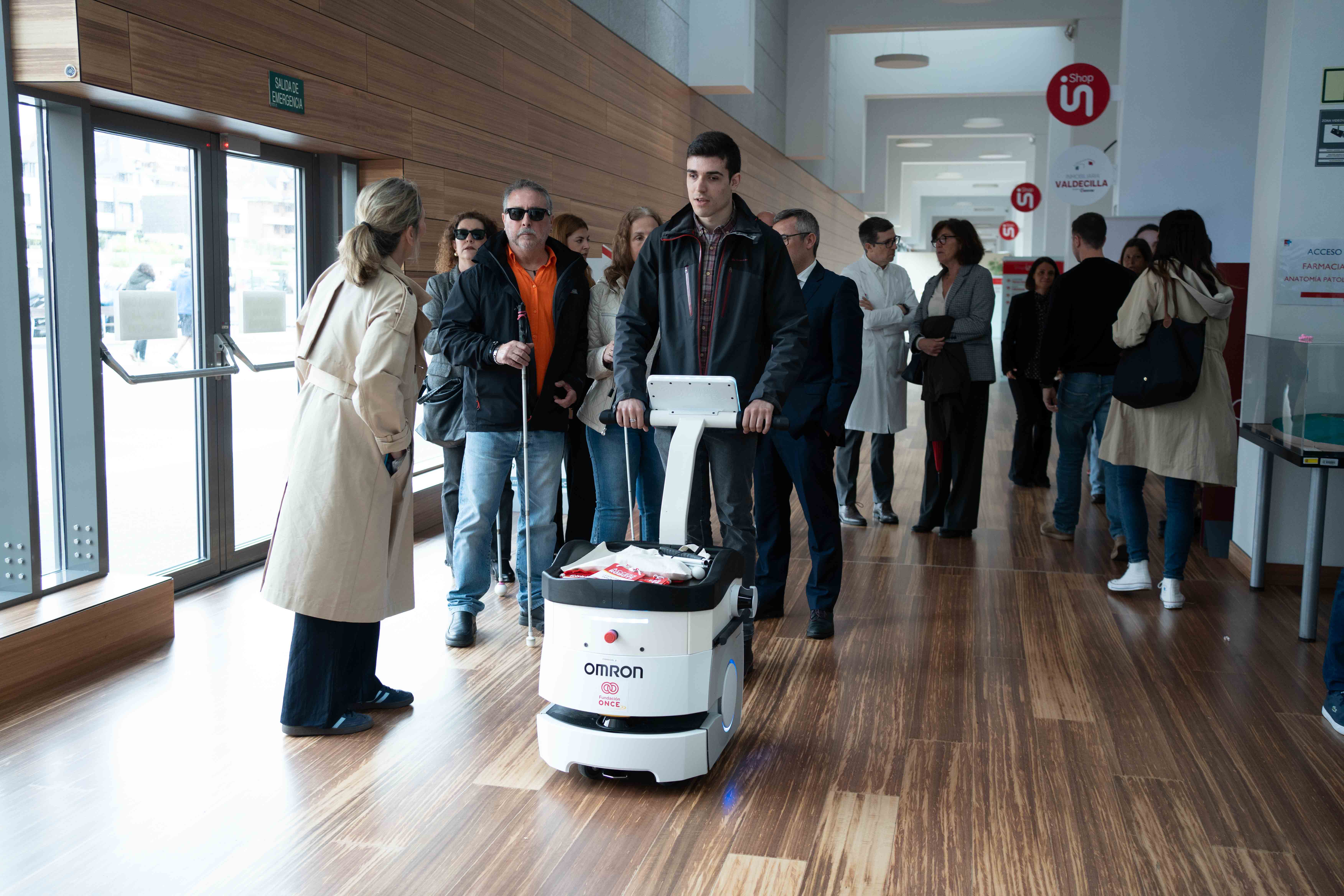 Persona con discapacidad visual realizando una demostración siendo guiada por el robot