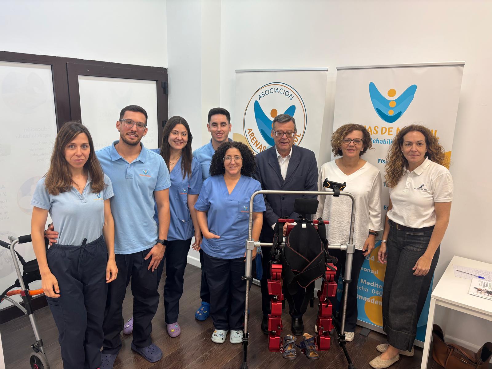 Foto de familia de los profesionales del centro de Mónsul y responsables de Fundación ONCE junto al exoesqueleto