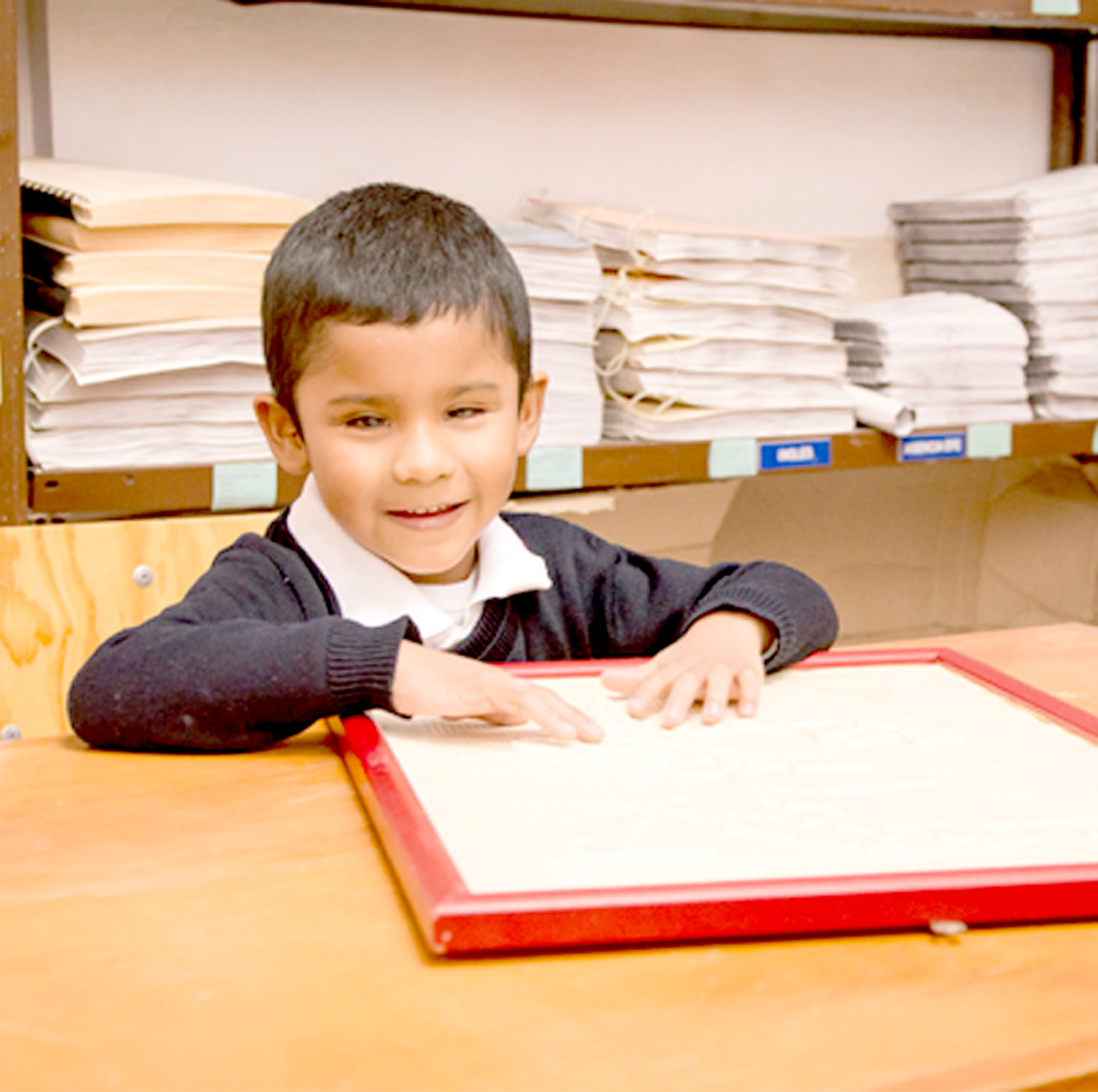 Un niño leyendo braille en el colegio