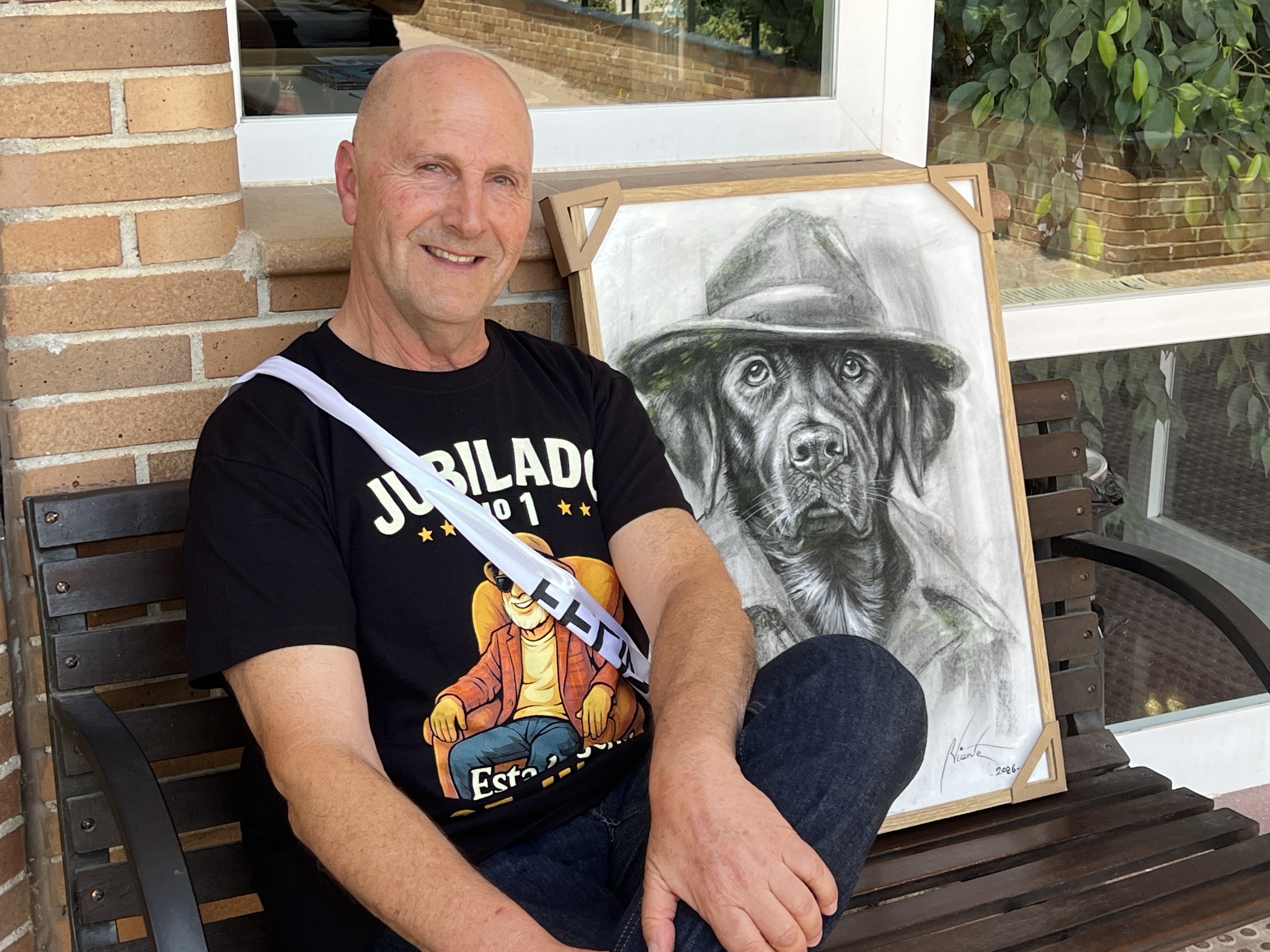 José Manuel Macarro junto al dibujo enmarcado de un perro