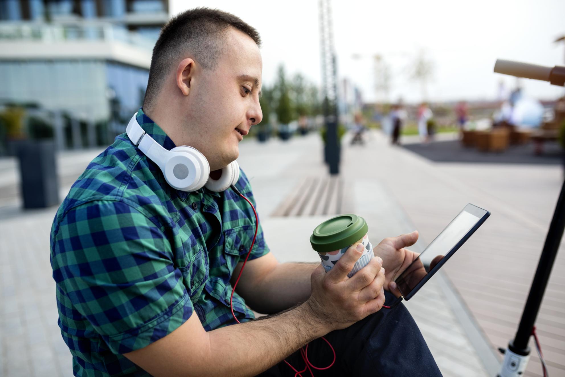 Persona con discapacidad con un audiolibro y una tablet