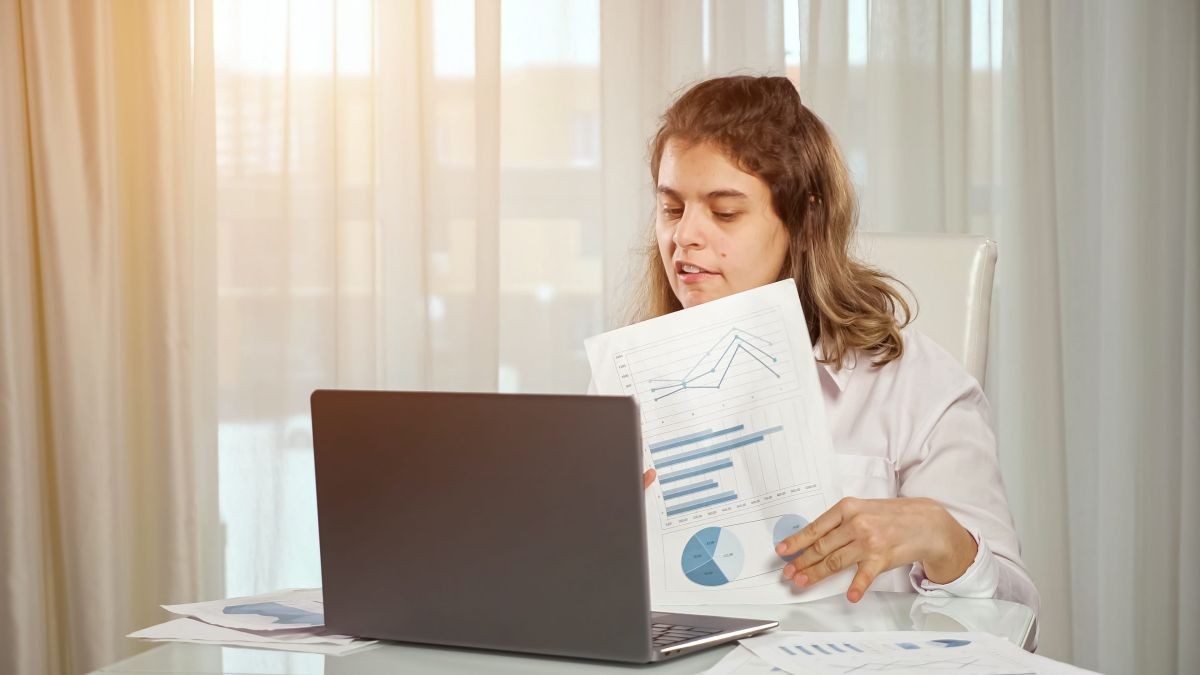 Una mujer con parálisis cerebral consulta documentos | Foto de 123RF/lenblr