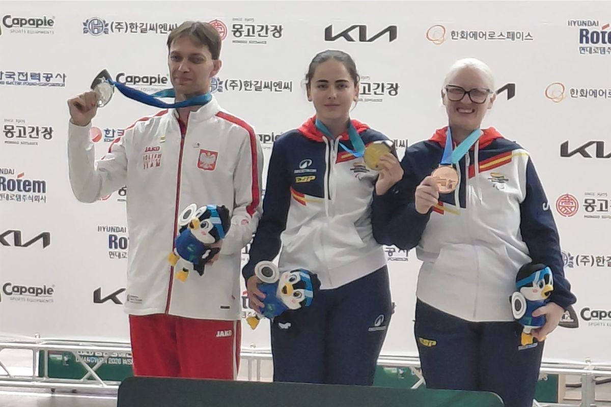 Podio Mundial Corea del Sur Tiro con Isabel en el centro mostrando su medalla de oro, junto a la polaca B. Rutkowski, plata, y Sonia Rivero, bronce.