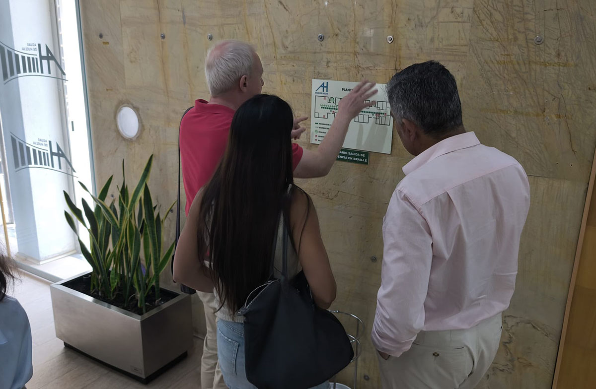 El director de Huelva toca uno de los planos accesibles instalados en Aguas de Huelva