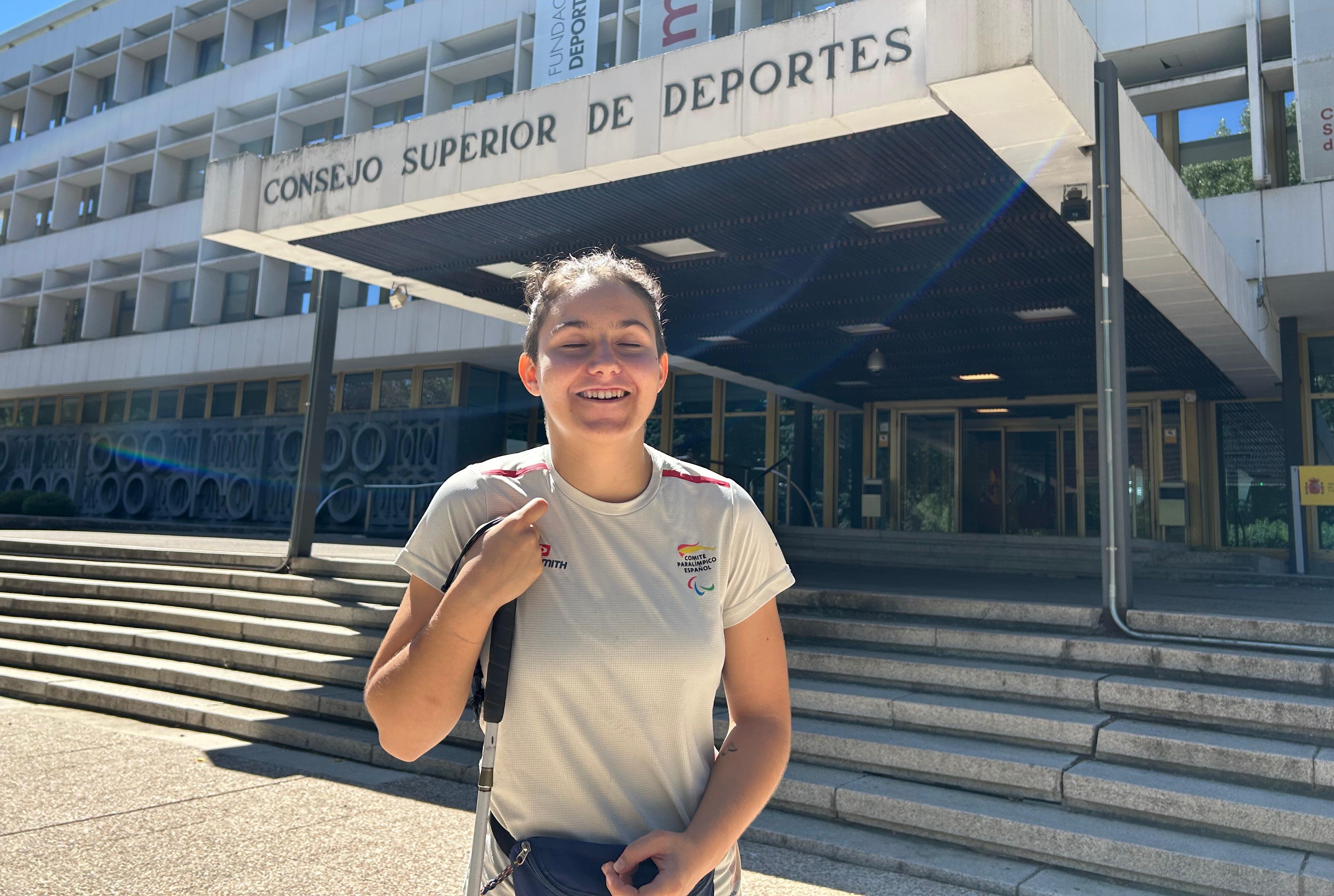 La judoka paralímpica María Manzanero posa sonriente, con su bastón blanco en mano, delante de la escalinata del Consejo Superior de Deportes