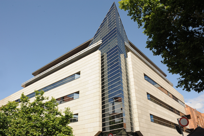 Edificio Pechuán en Madrid visto desde una esquina, con arquitectura funcional de hormigón y cristaleras.