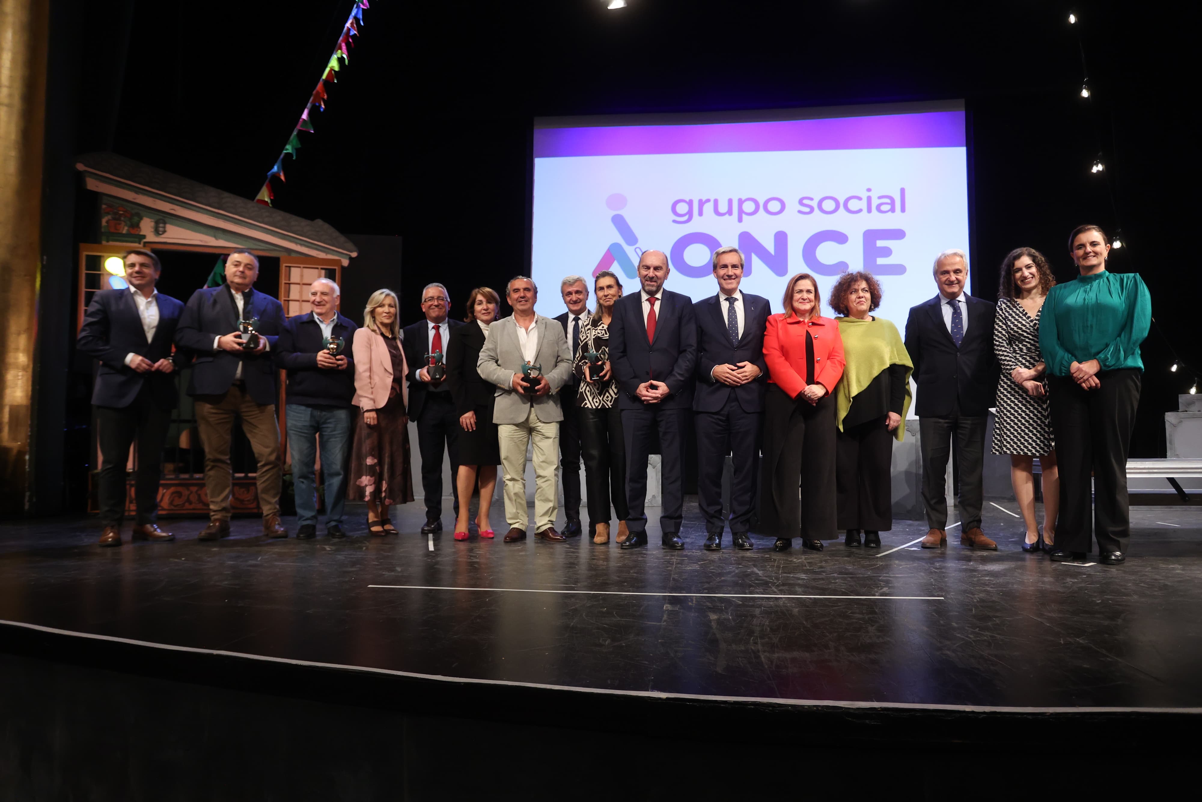Foto de familia de premiados y autoridades sobre el escenario del Teatro Filarmónica de Oviedo