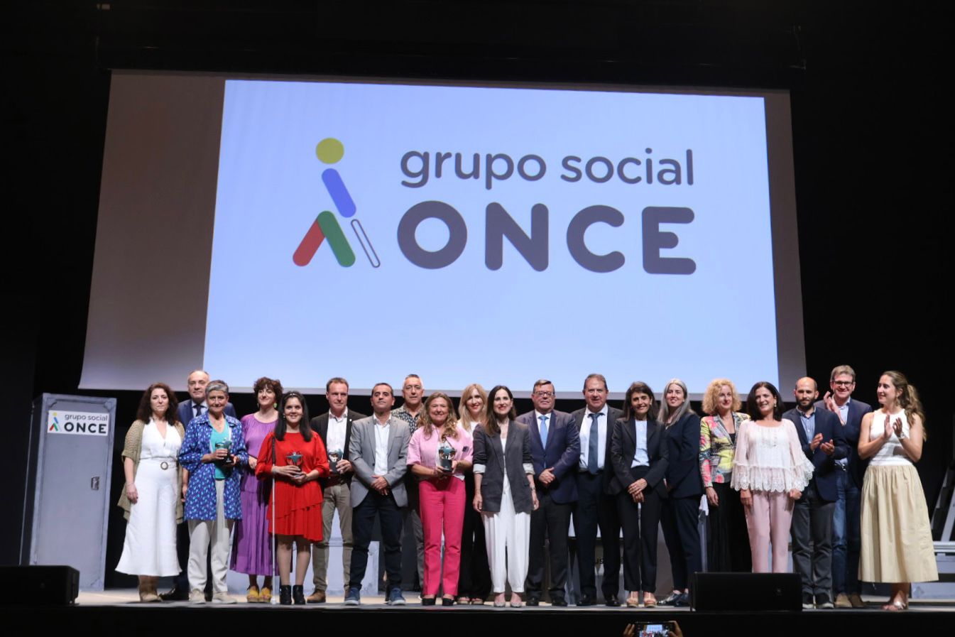 Foto de familia sobre el escenario y ante una pantalla con el logo del Grupo Social ONCE detrás