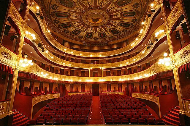 Teatro municipal de Girona visto desde dentro, estilo clásico y butacas rojas, palcos y varias plantas