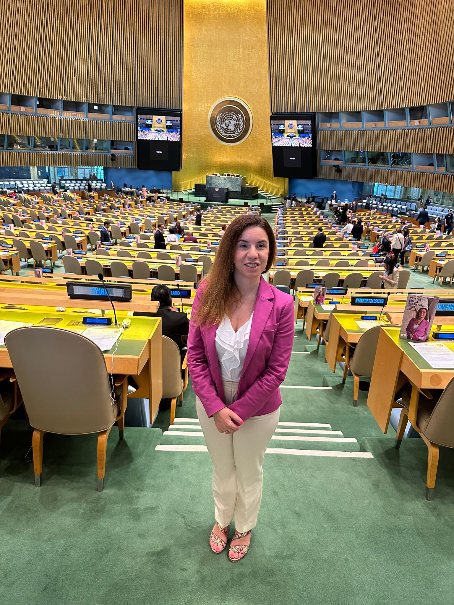 Plano general de Natalia Guala con sala de la ONU al fondo