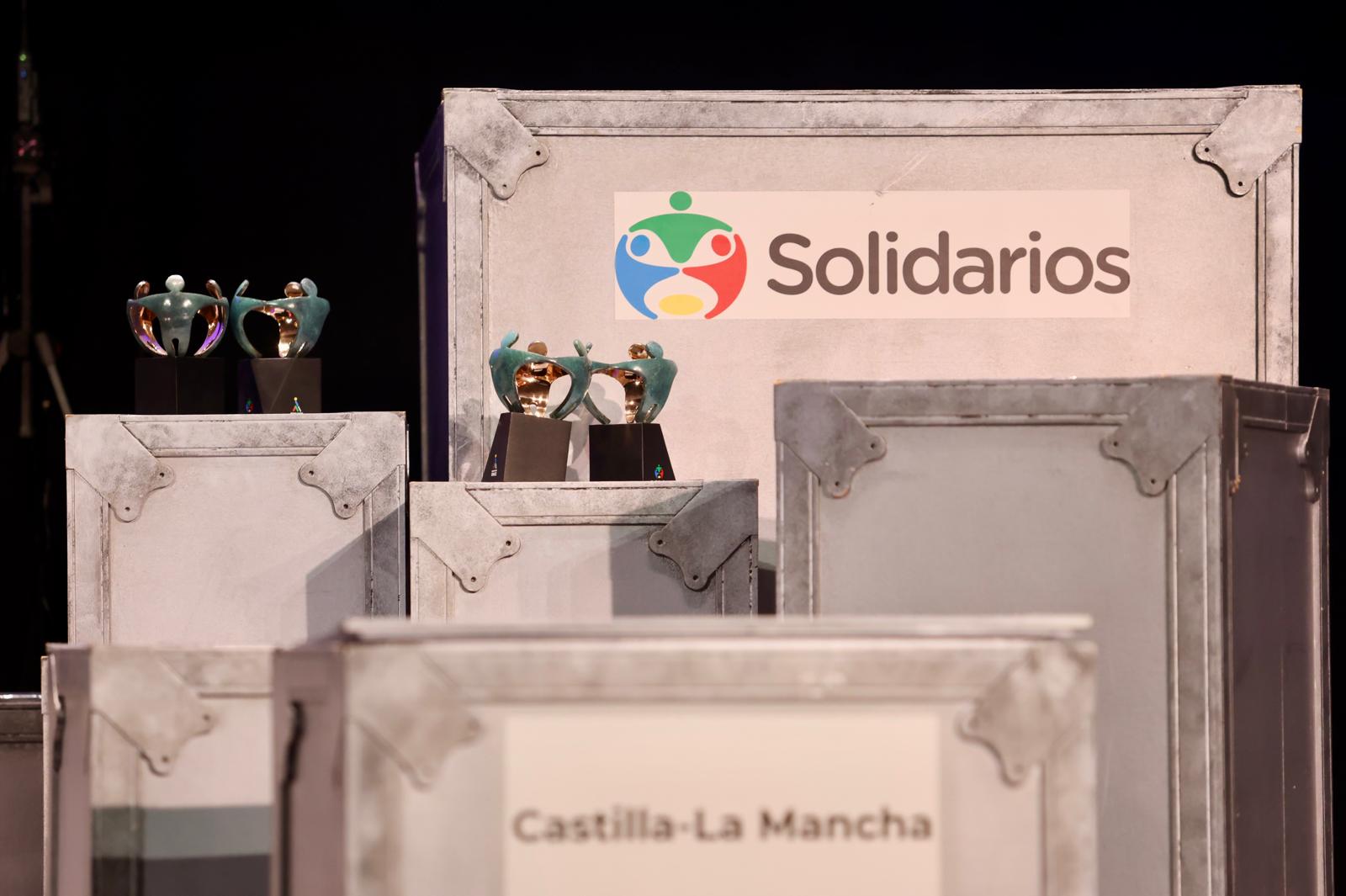 Detalle de los baúles del escenario. En uno de ellos se lee Premios Solidarios y en otro Castilla-La Mancha. Sobre ellos están las estatuas de los Premios Solidararios