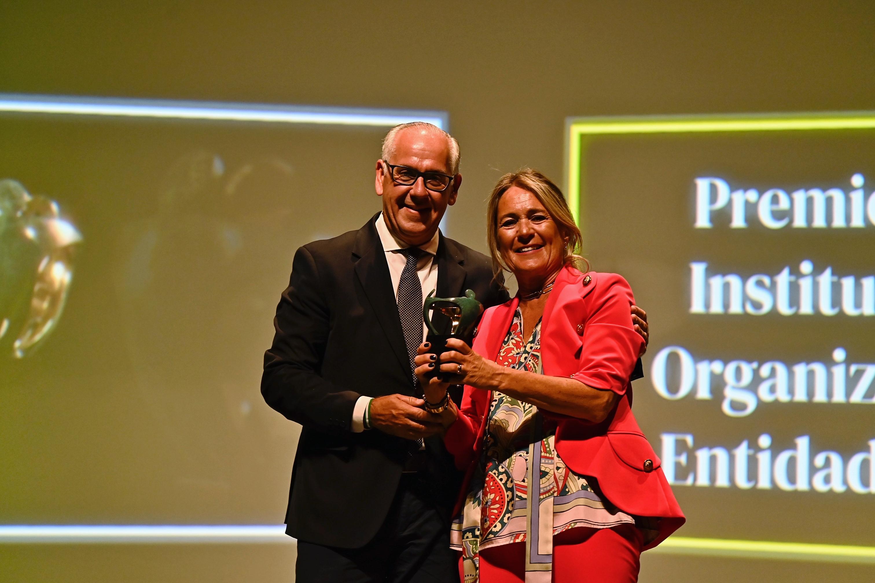 Rosario Morales, presidenta de la Federación Andaluza de Asociaciones de Familias de Acogida y Colaboradoras, recogiendo el premio que le entregó el delegado del Gobierno de la Junta de Andalucía en Jaén, Jesús Manuel Estrella.
