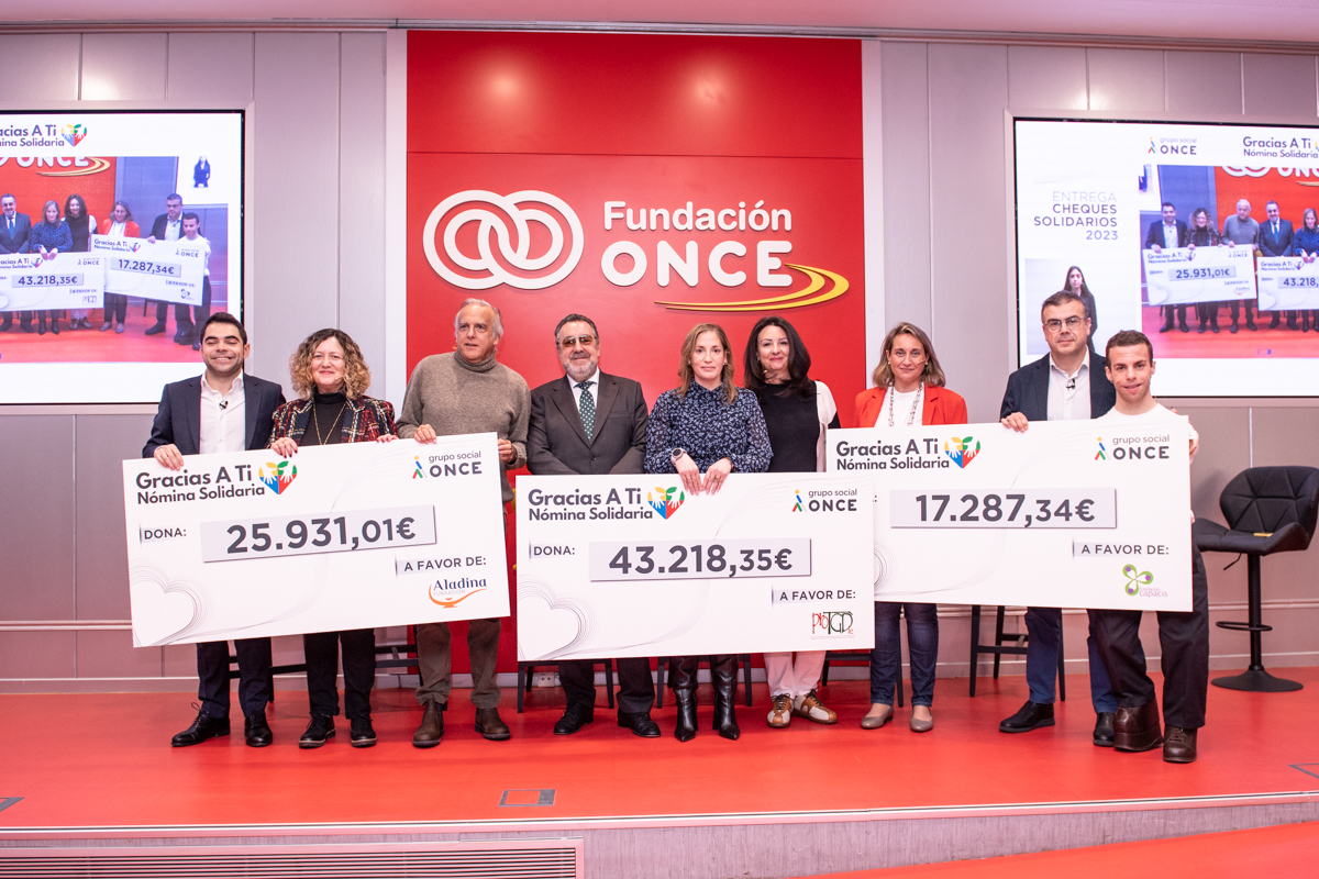 Foto de familia sobre el escenario con todos los premiados, embajadores y presentadores con los cheques gigantes