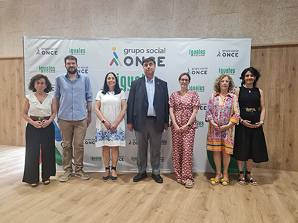 Foto de familia delante de un panel con logos del Grupo Social ONCE - Iguales