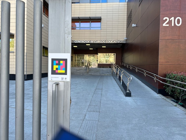 Entrada principal del CRE de Madrid con detalle de en la verja de metal de la entrada de un código navilens