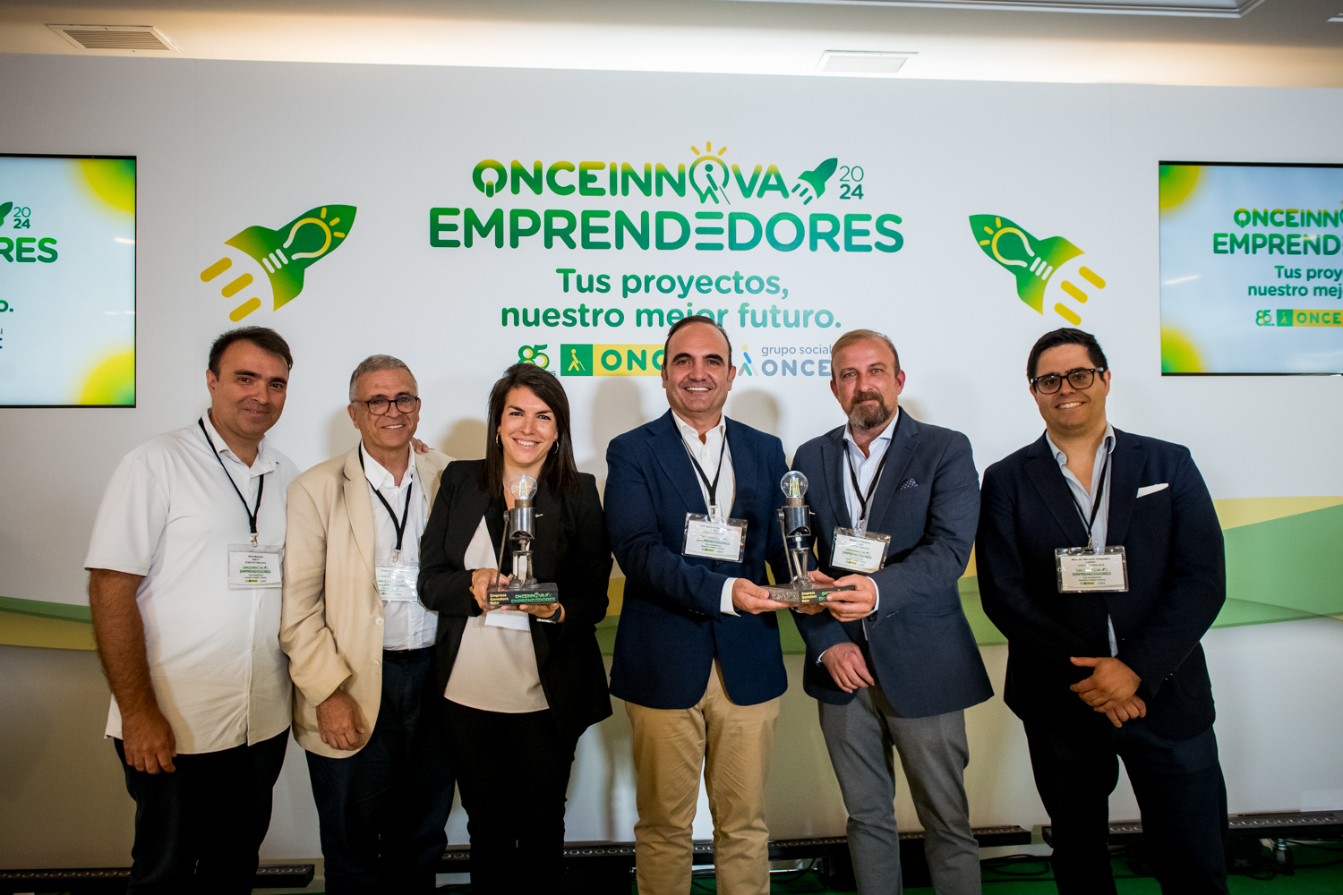 Se muestra a representantes de las startups ganadoras del Reto ONCE Innova Emprendedores 2024 posando con sus trofeos. Se encuentran sonrientes y acompañados de miembros del jurado, con el logotipo del evento y el lema “Tus proyectos, nuestro mejor futuro” en el fondo.