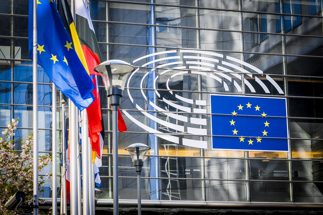 Fachada principal del Parlamento Europeo, cristalera con banderas