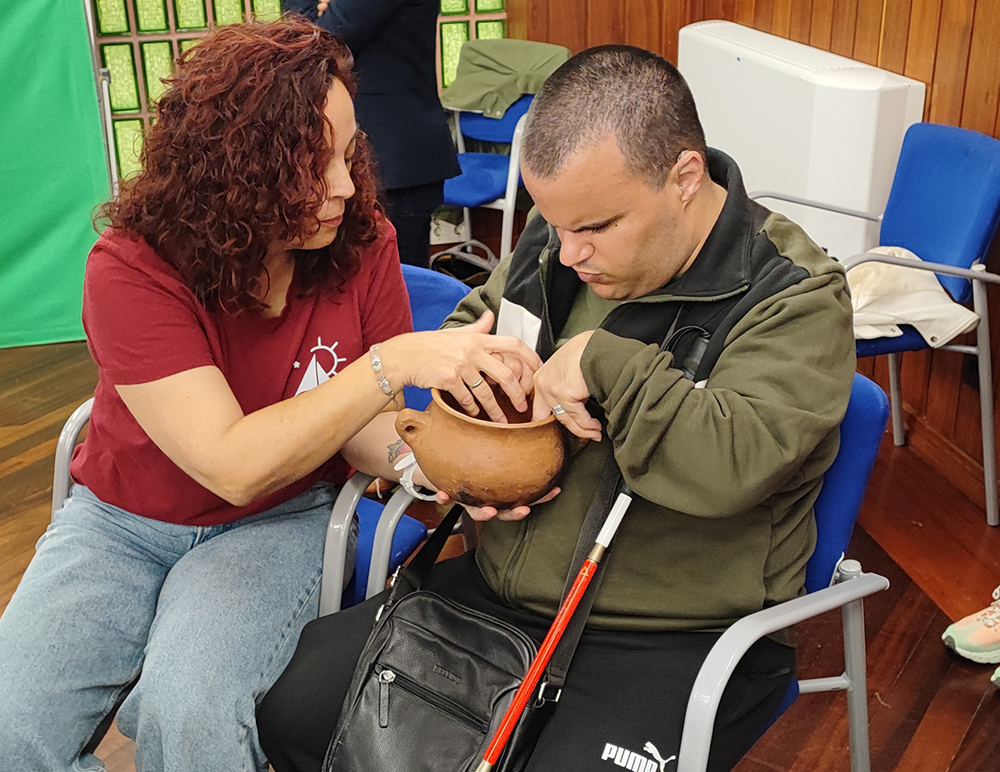 Uno de los visitantes con sordoceguera reconociendo una pieza del Museo