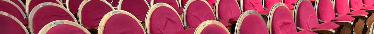 Detalle de varias butacas rojas y de madera en un teatro antiguo
