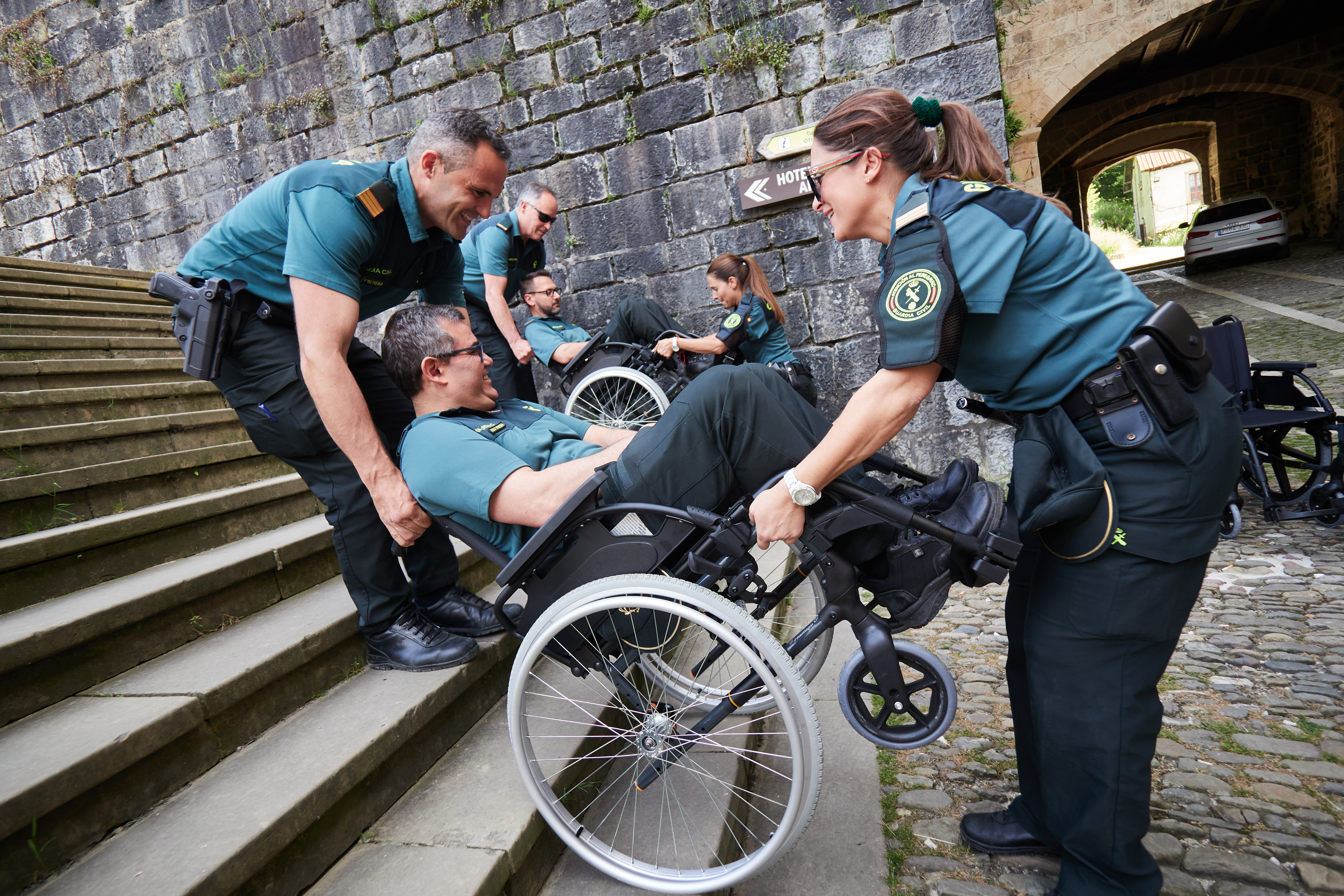 Guardias Civiles bajan a un usuario en silla de ruedas por unas escaleras Guardias Civiles bajan a un usuario en silla de ruedas por unas escaleras