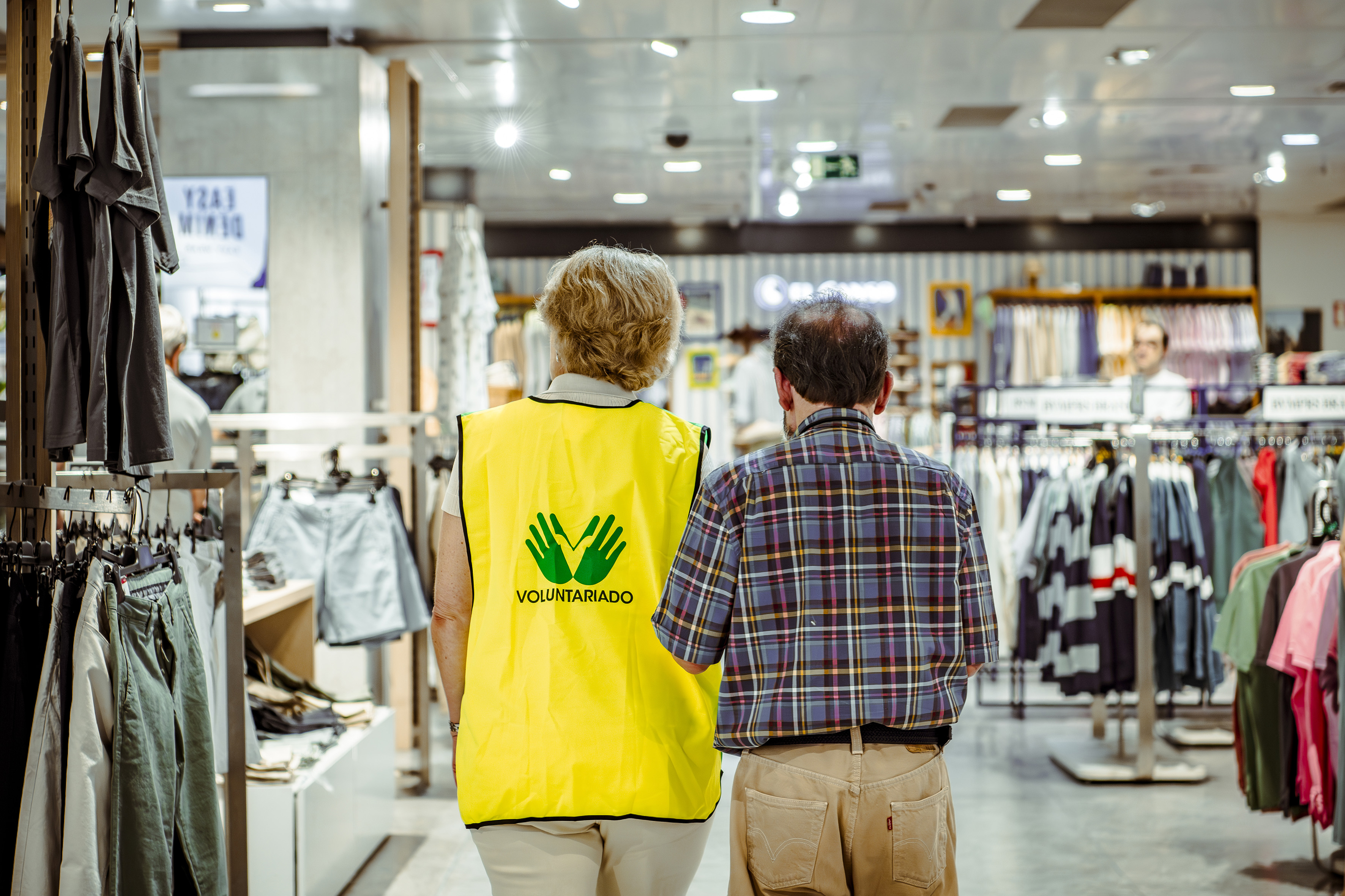 Voluntaria de la ONCE realizando un acompañamiento a un afiliado en un centro comercial