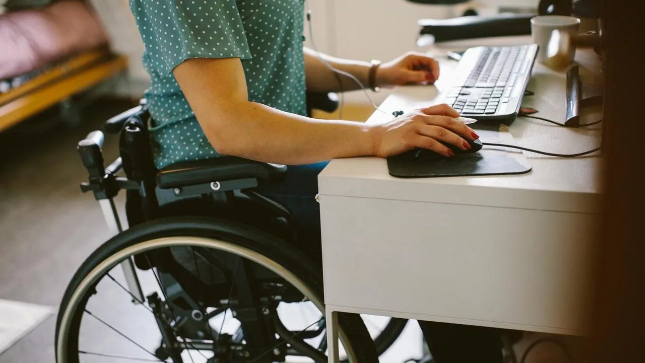 Una mujer en silla de ruedas utilizando un PC