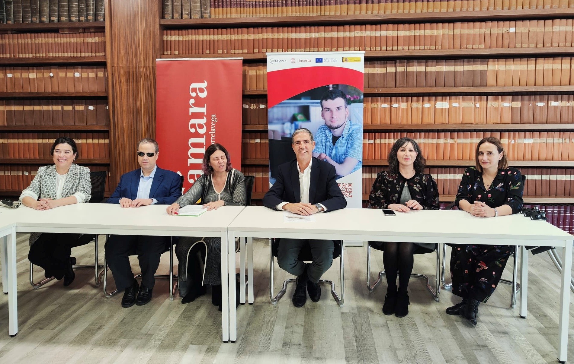 Foto de familia de los responsables de la Cámara de Torrelavega e Inserta empleo, sentados en una mesa