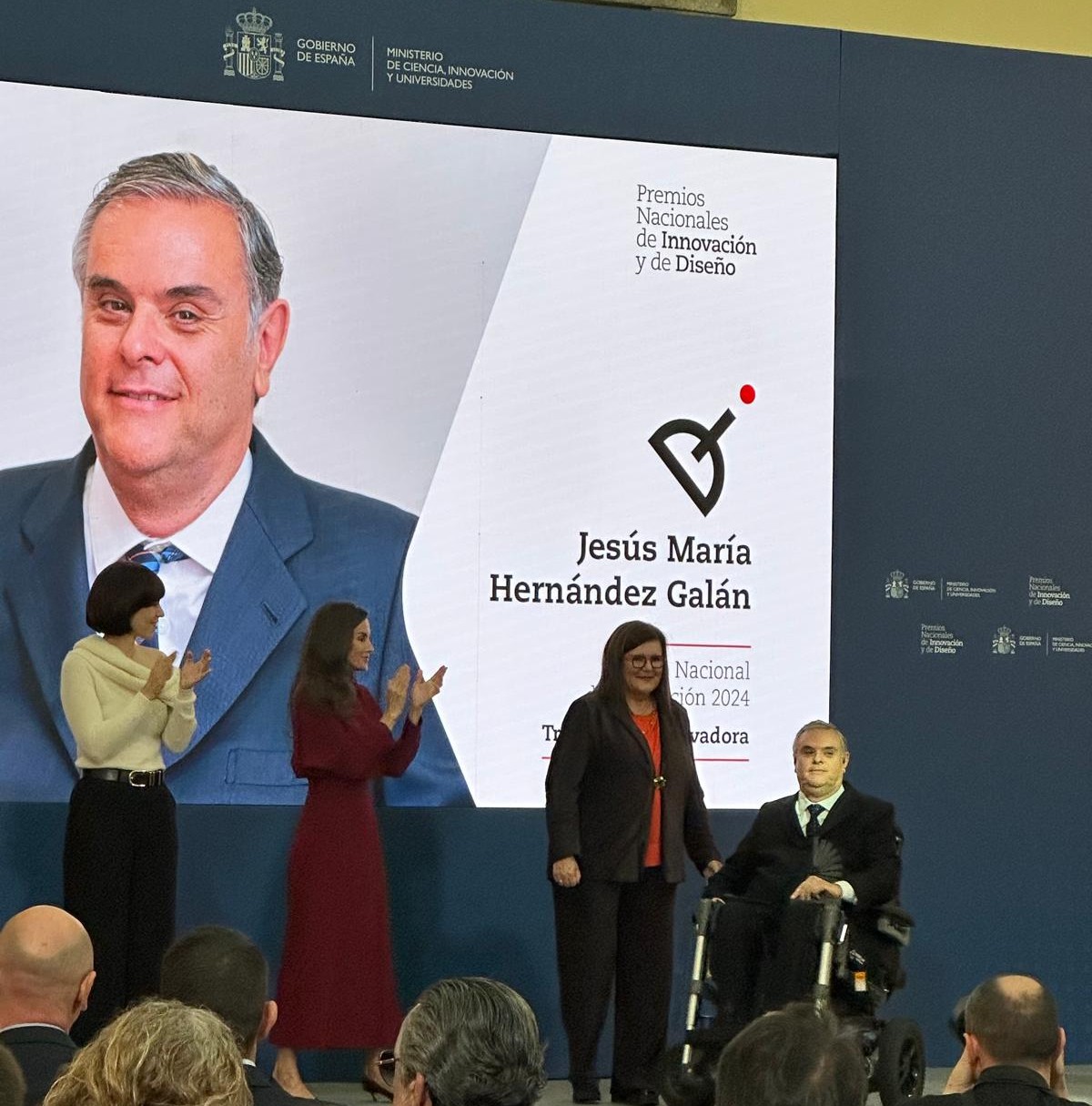 Jesús Hernández sobre el escenario tras recoger su premio de las manos de la reina, también sobre el escenario junto a la ministra Diana Morant