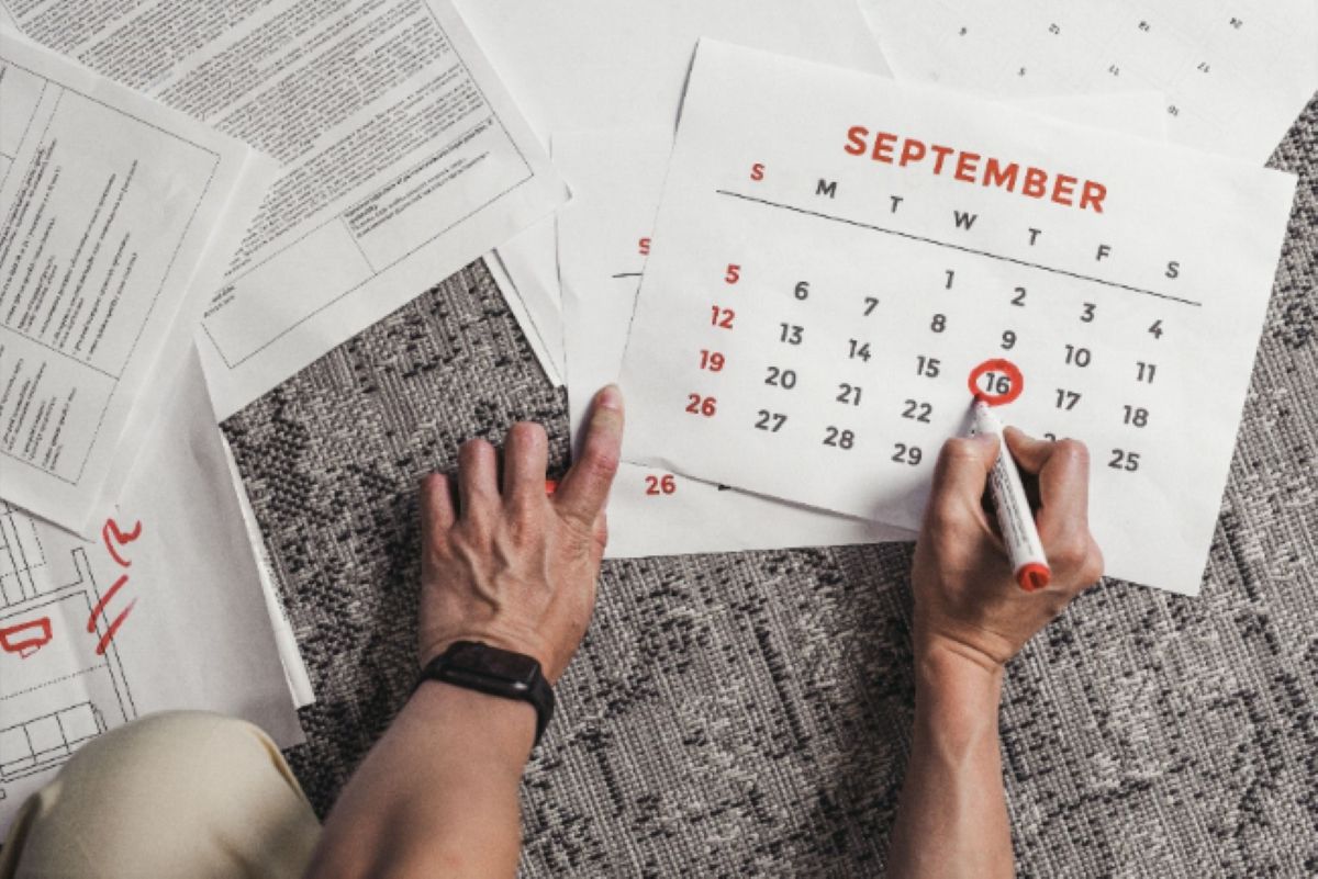 Una persona señala una fecha en el calendario de septiembre. 