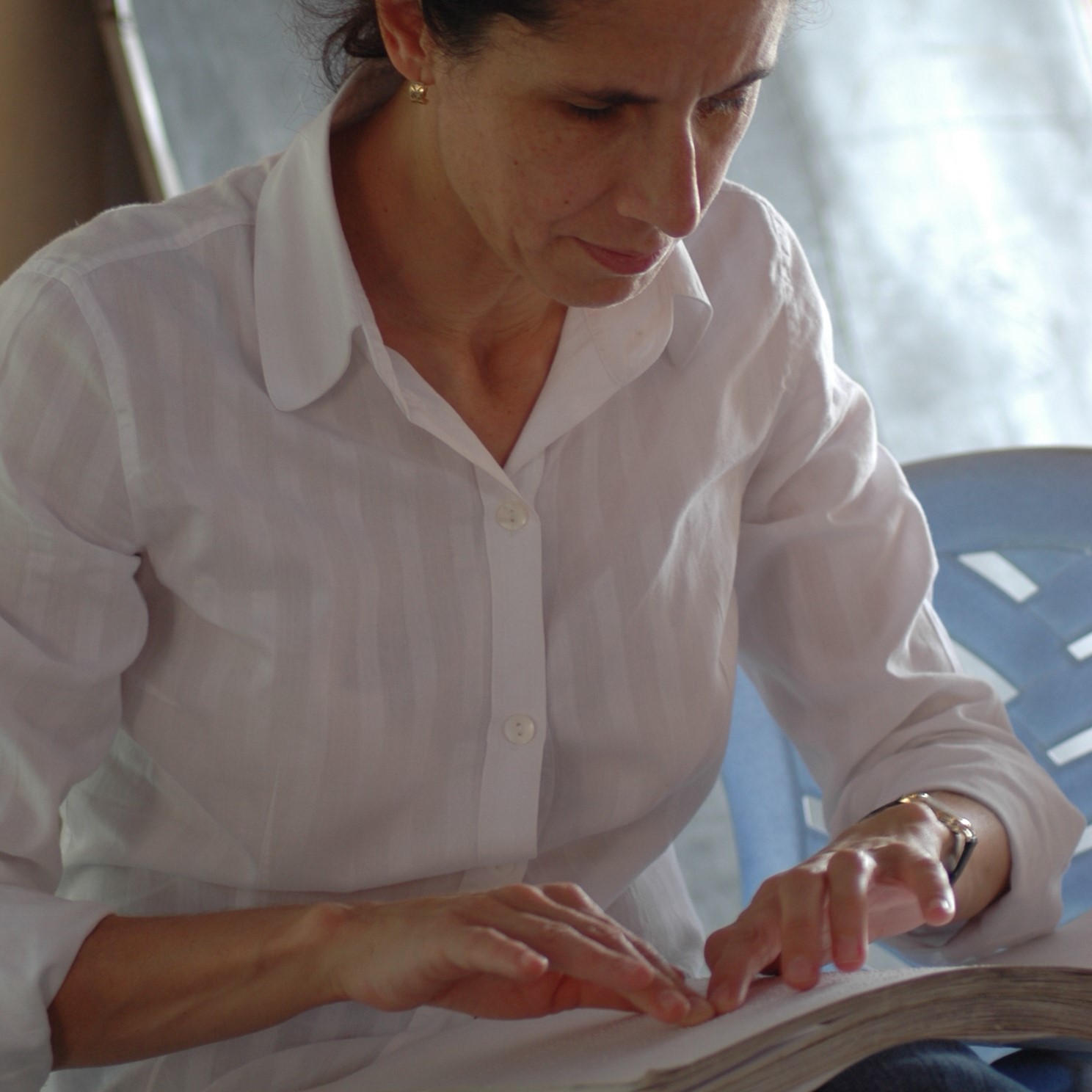Ana Peláez leyendo un libro en braille