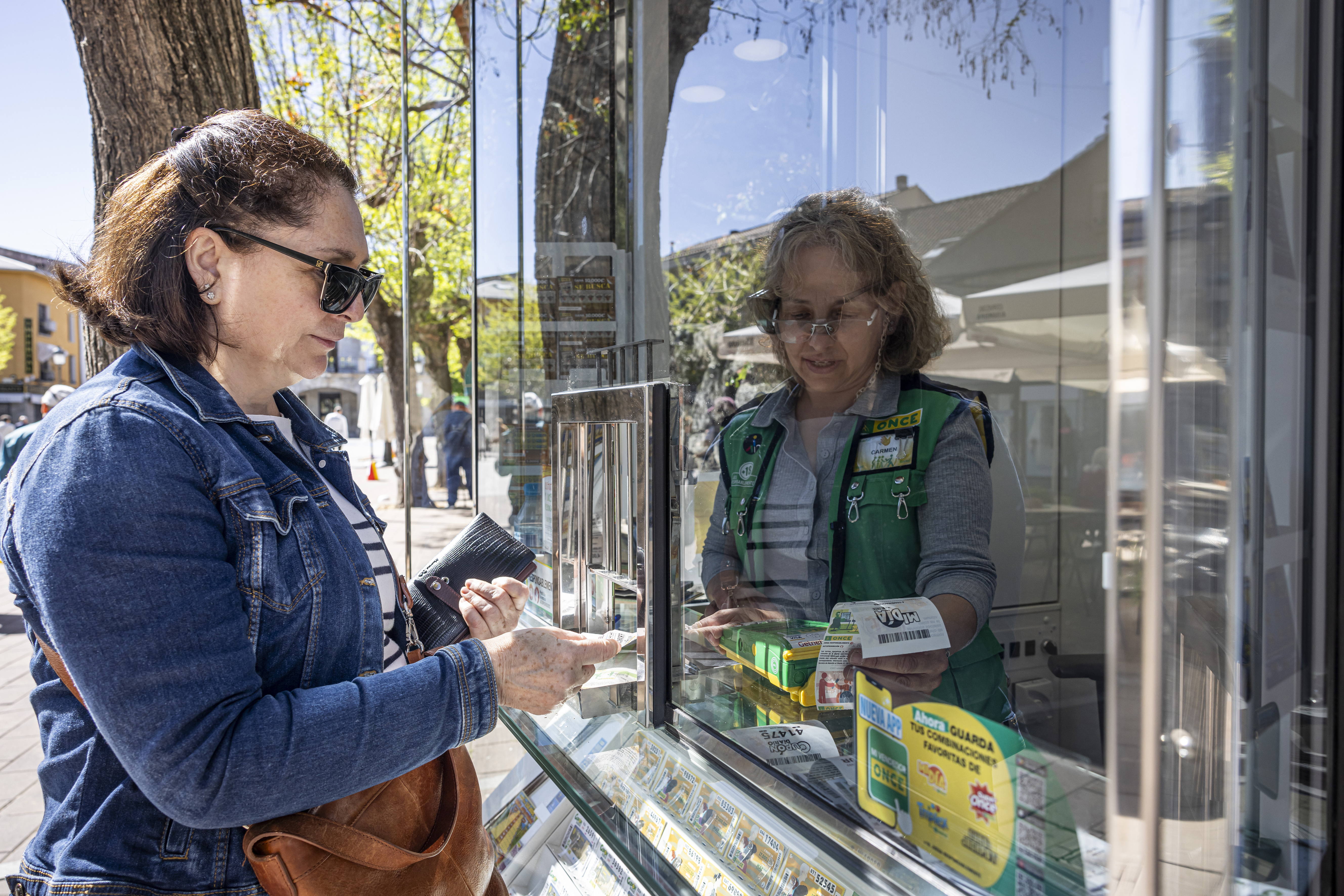 Mujer comprando loteria de la ONCE en un quiosco
