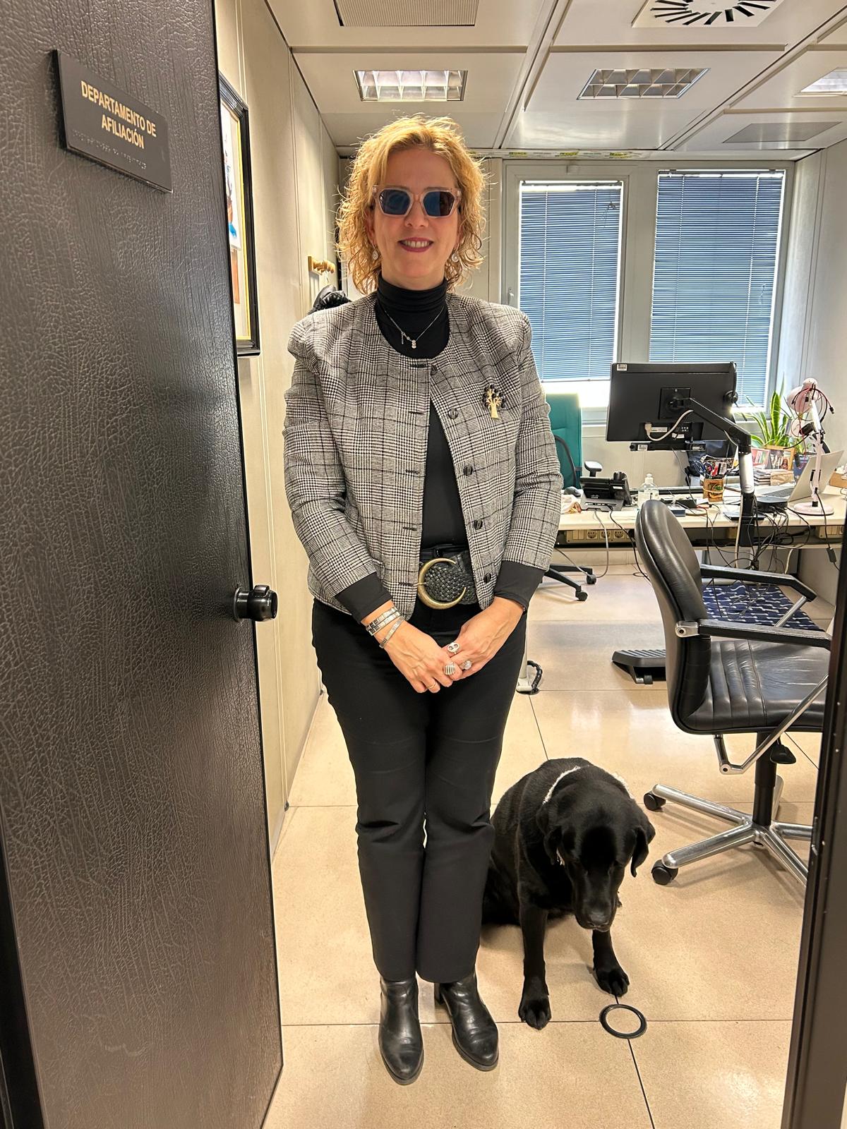 Ana Belén Morejón junto a su perra guia en la entrada de su despacho
