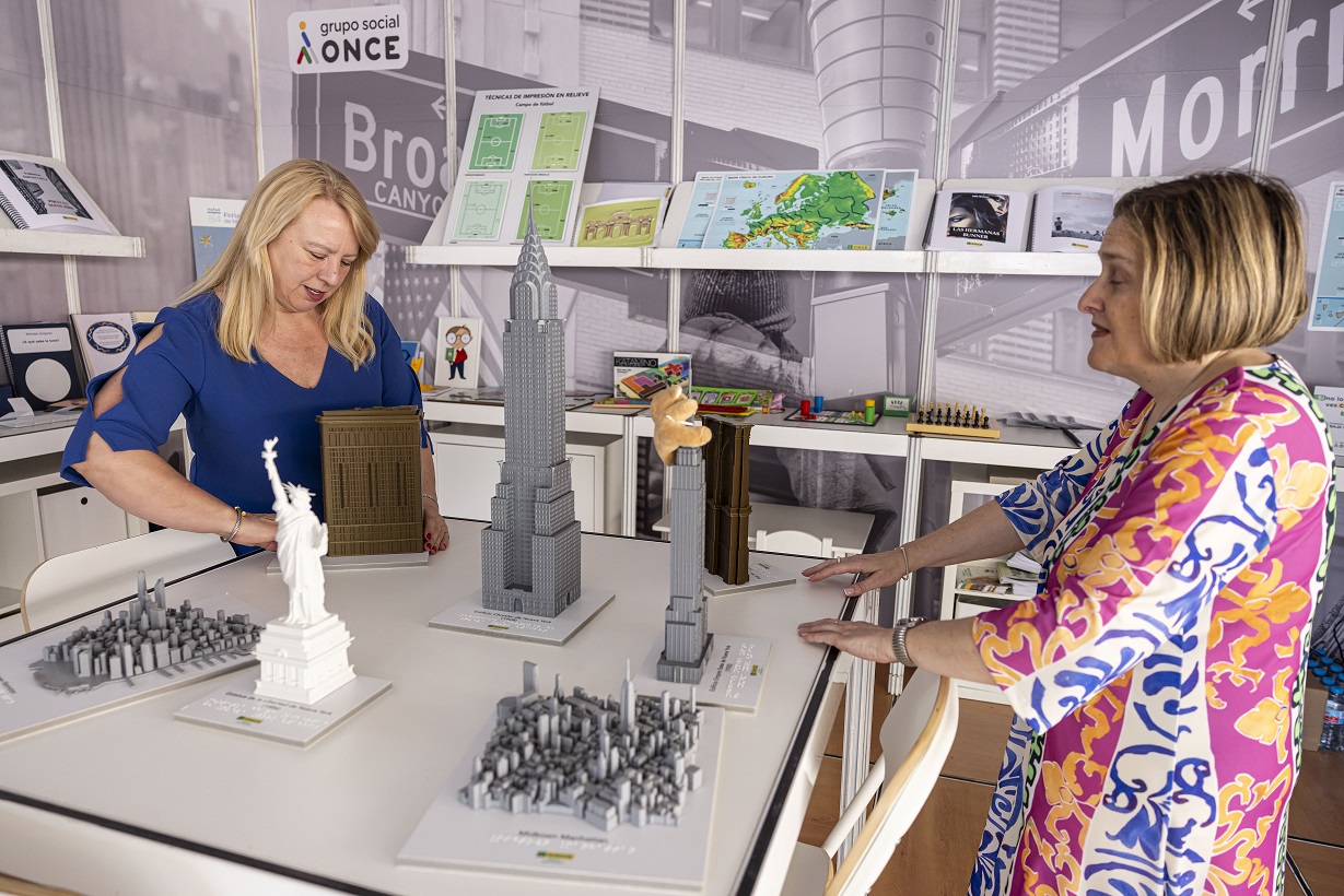 Carmen Bayarri, a la izda., e Imelda Fernández, a la derecha, en el estand de la ONCE en la última edición de la Feria del Libro de Madrid 2025