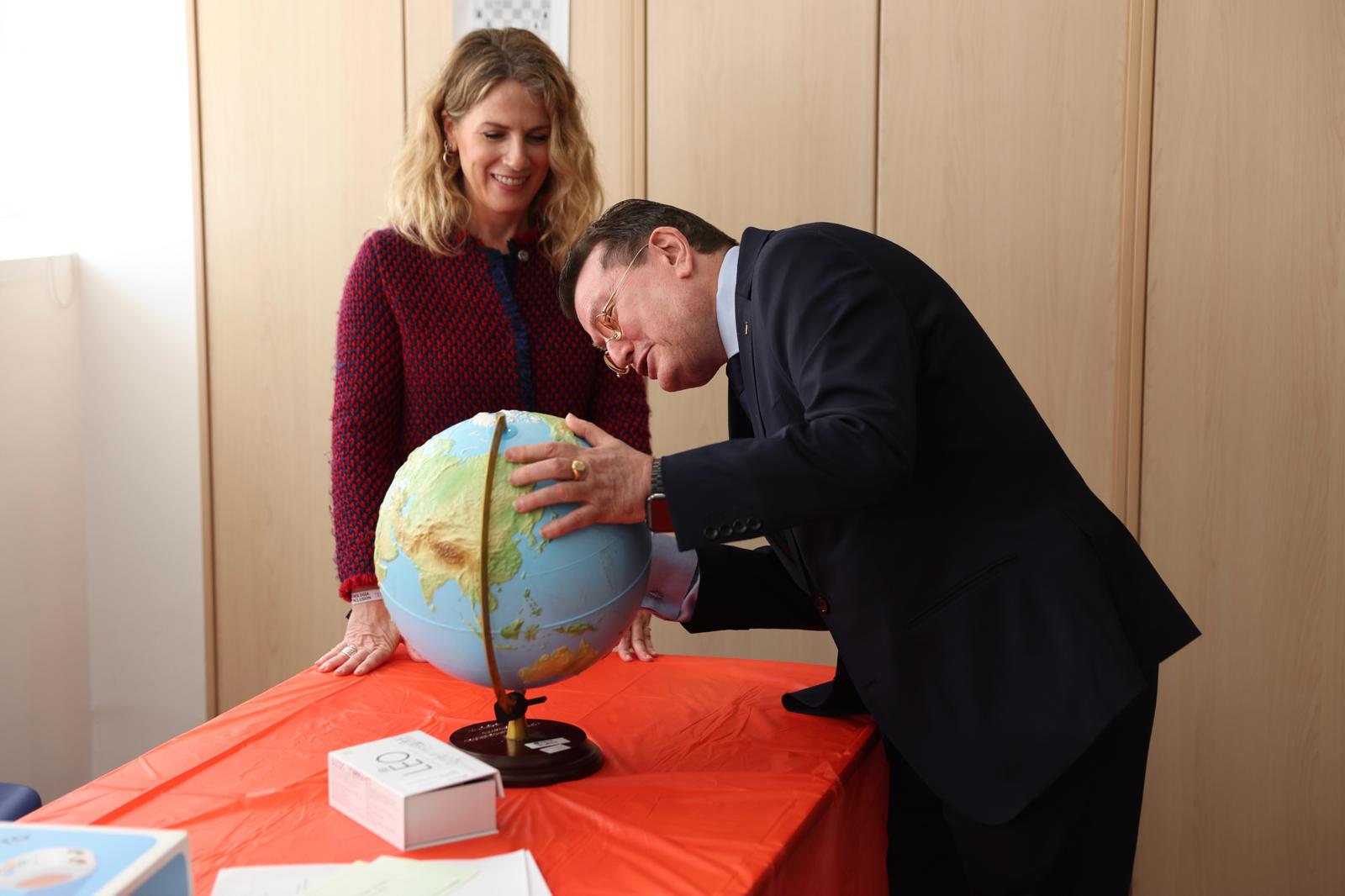 Ángel Sanchez junto a la vicepresidenta del PA, observan un globo terráqueo accesible en la exposición "Los Cuatro Caminos"