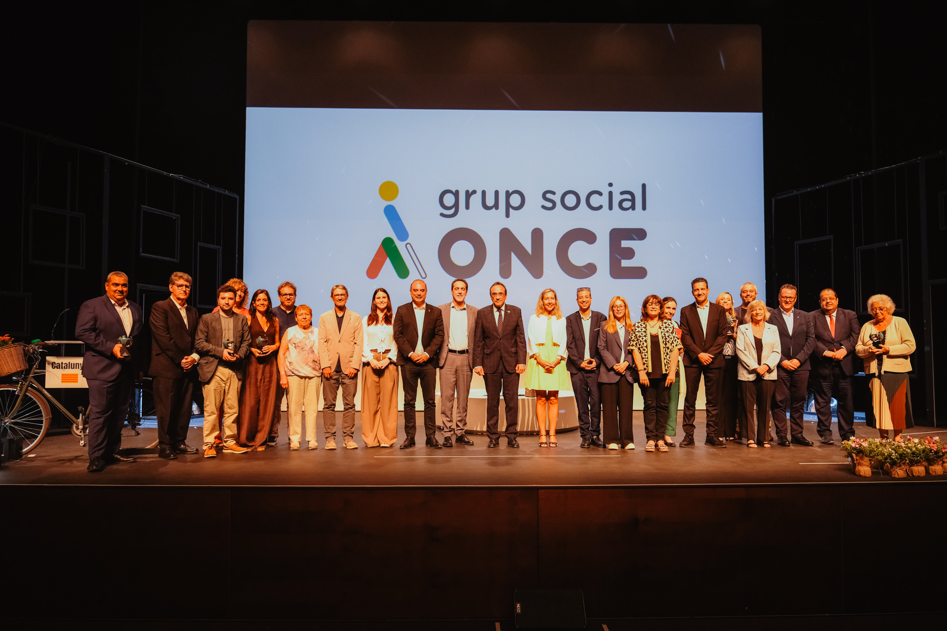 Foto de familia de los premiados y autoridades en el escenario