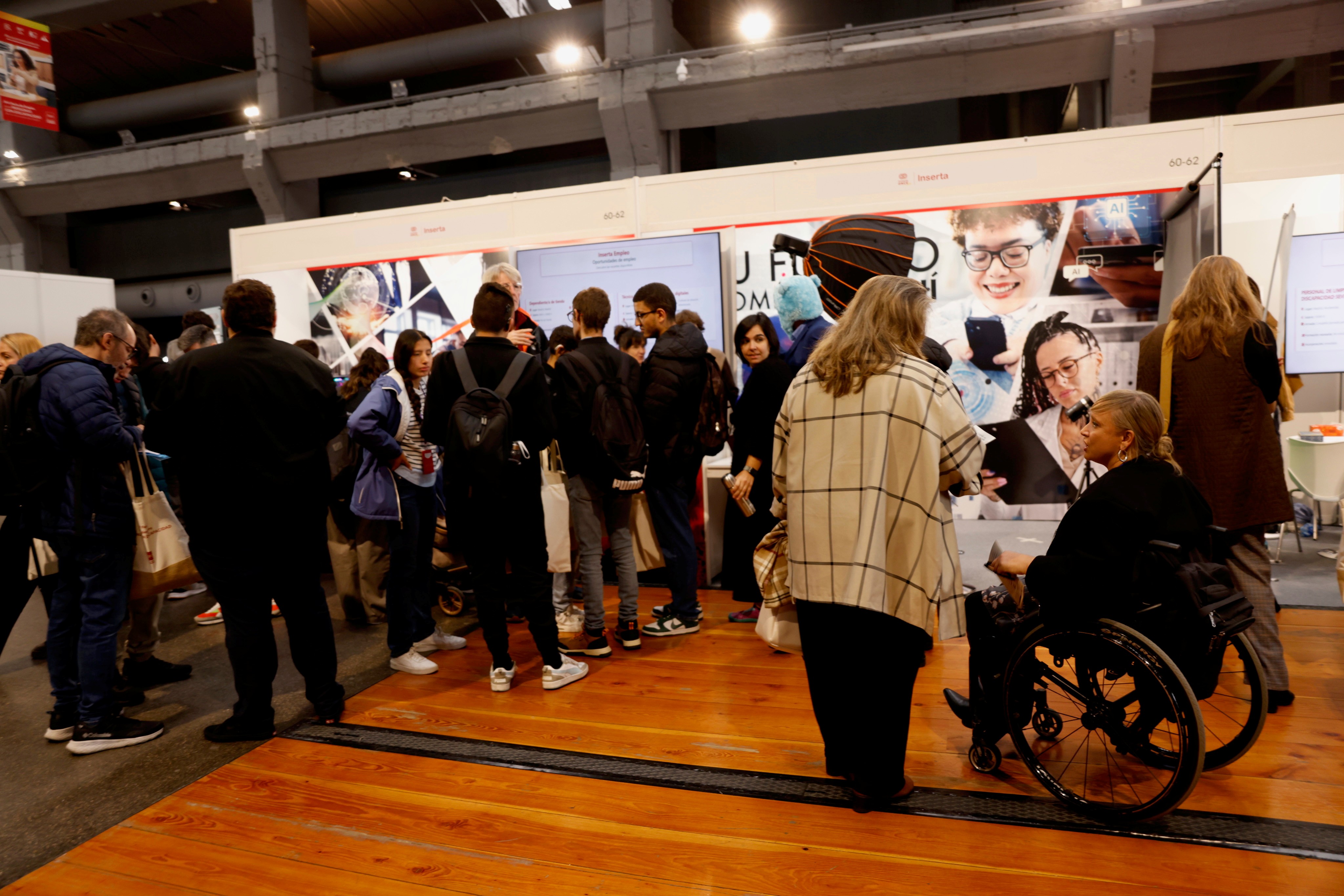 Stand de Inserta en la feria, con muchas personas, algunas con discapacidad, alrededor