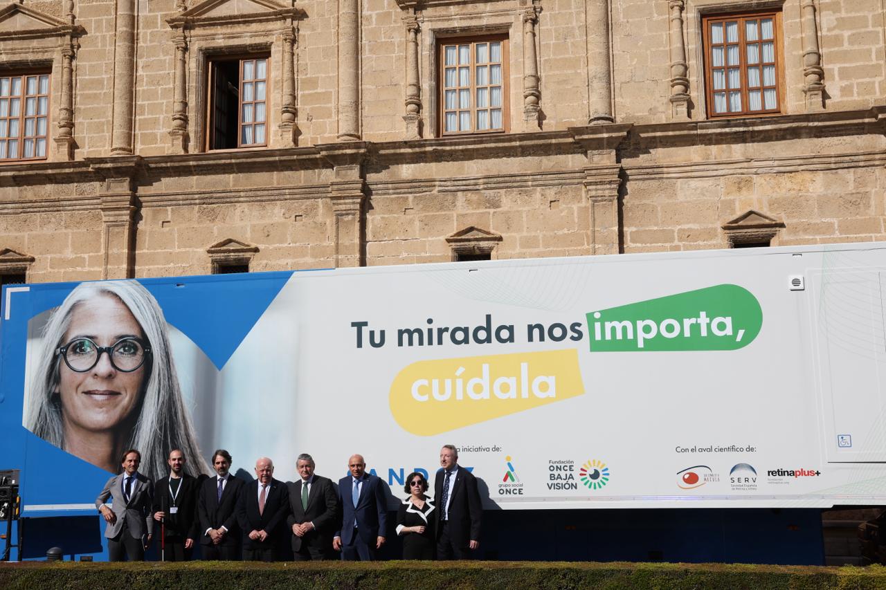 Foto de familia de las autoridades del Parlamento junto a responsables de la ONCE en el camión de la FOBV