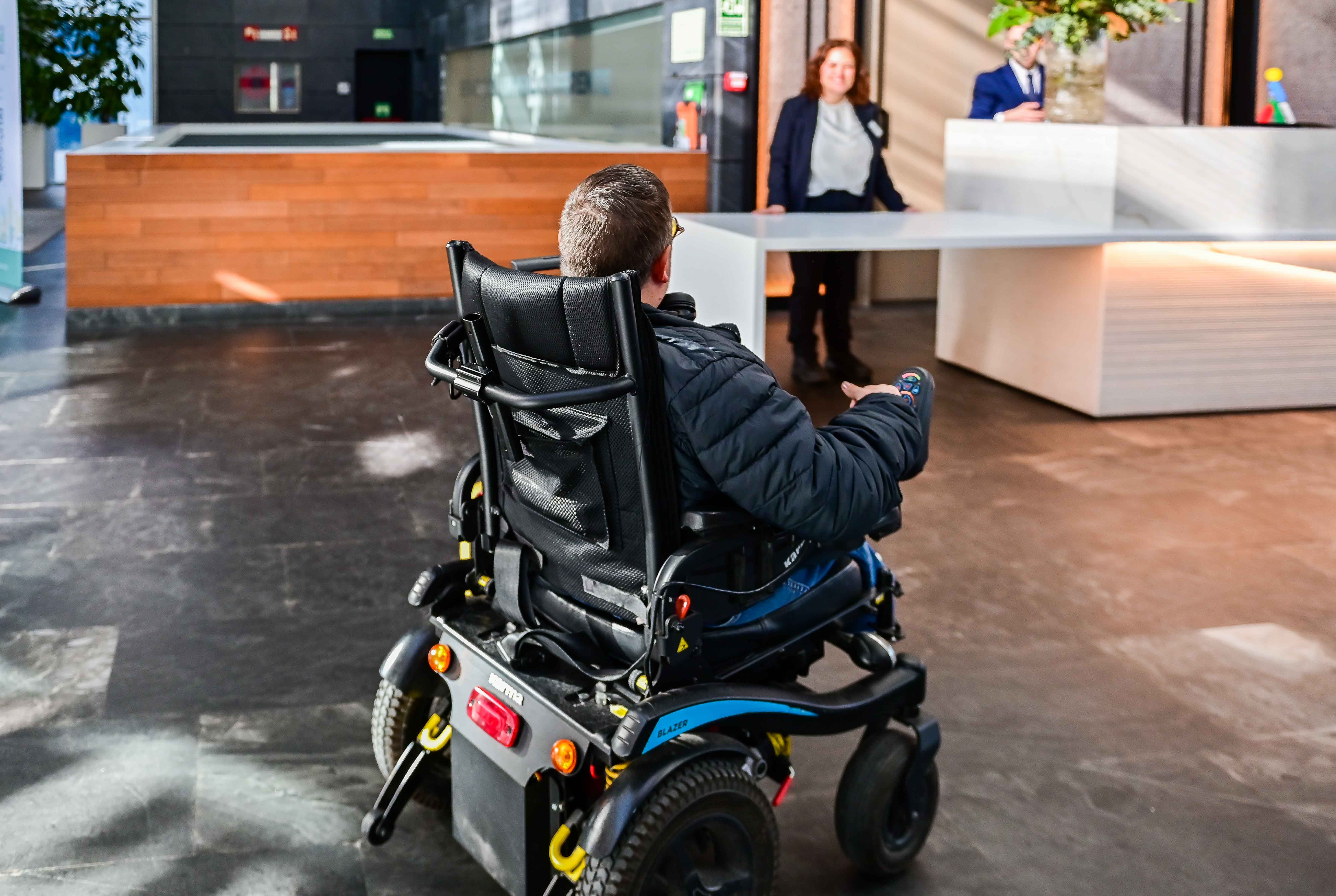 Persona en silla de ruedas entrando a la recepción de un hotel Ilunion