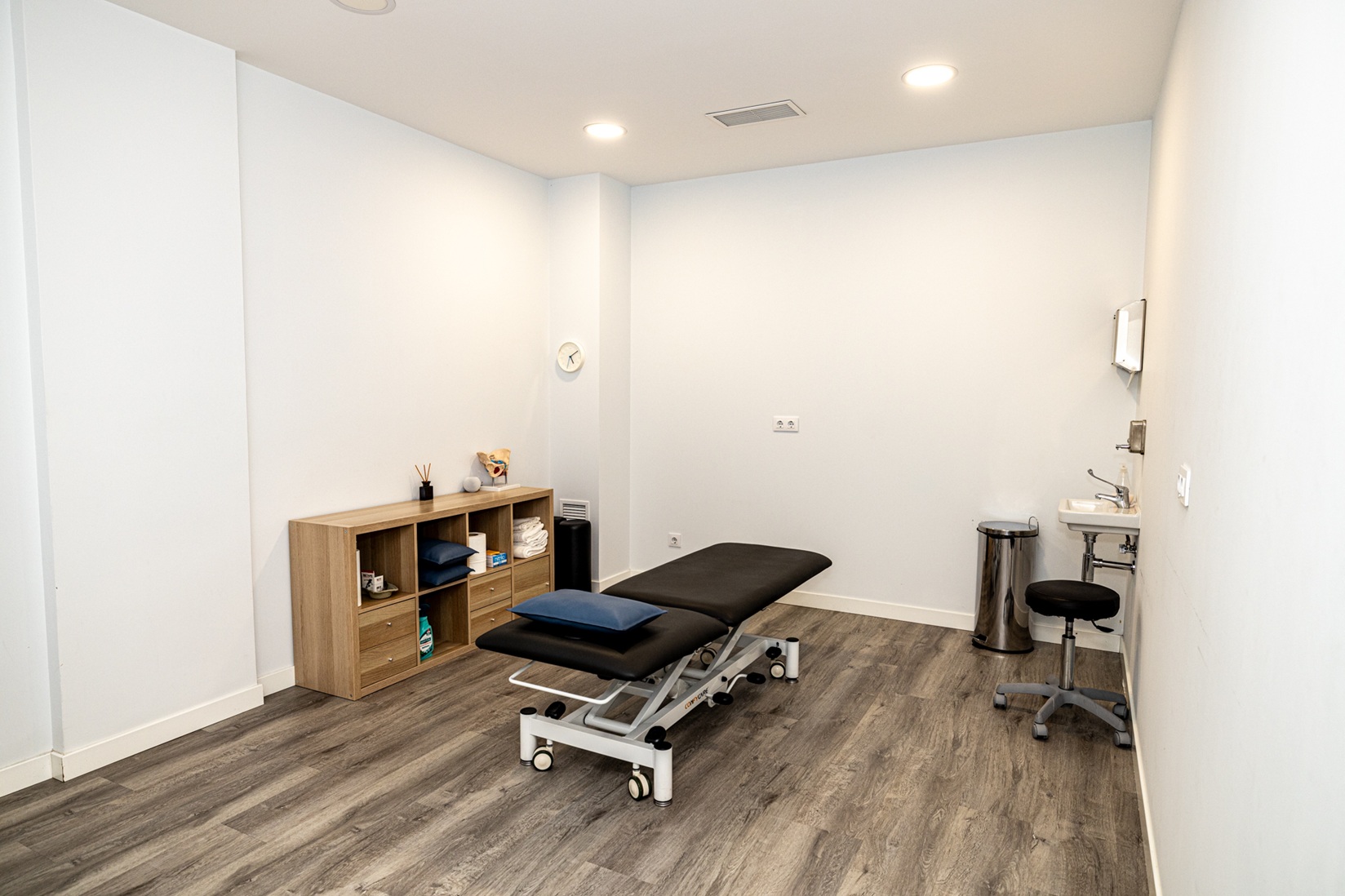 Interior de la clínica, con una mesa y un mueble de almacenamiento con material