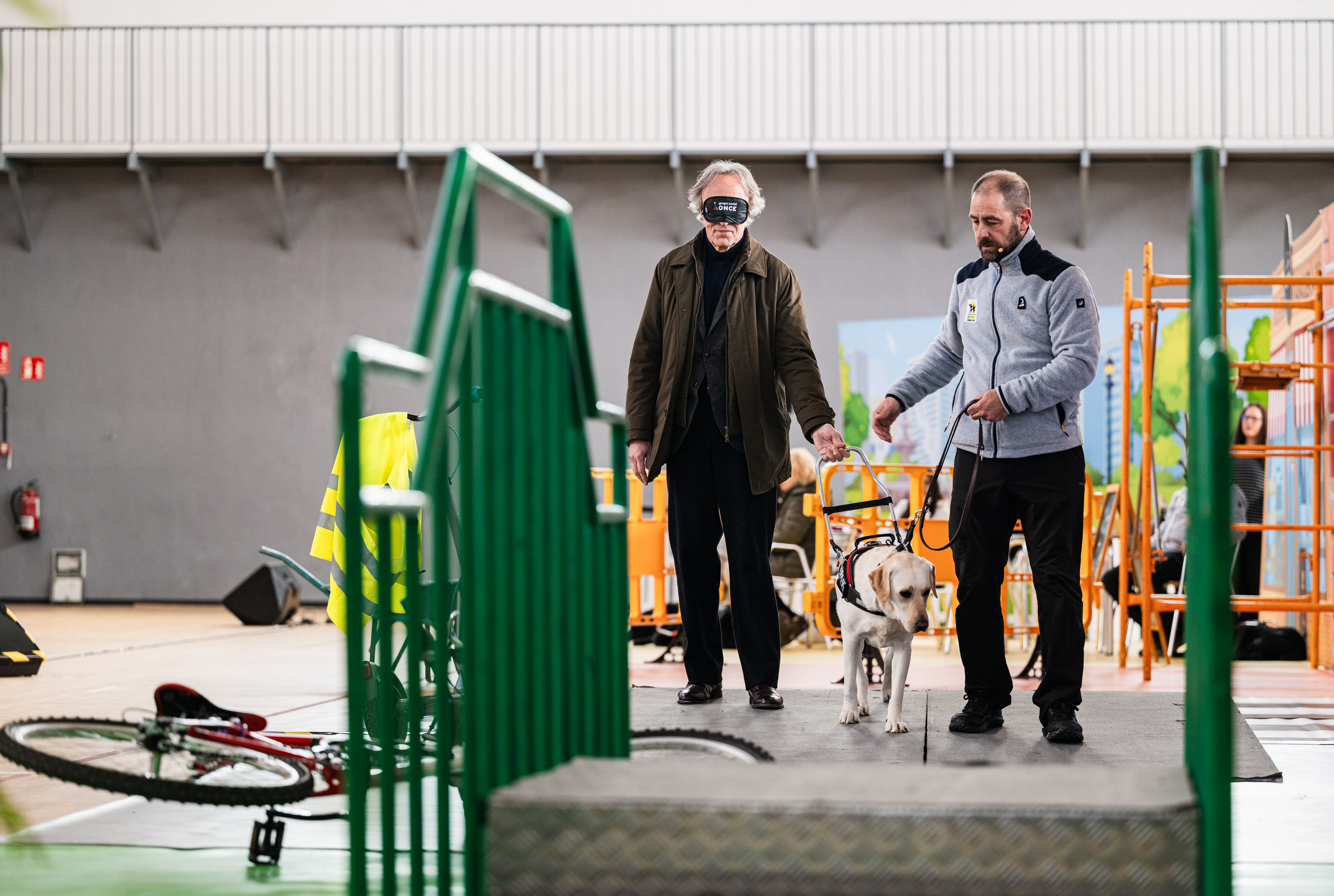 Indalecio Sánchez realizando un recorrido con antifaz guiado por un perro guía durante la exhibición