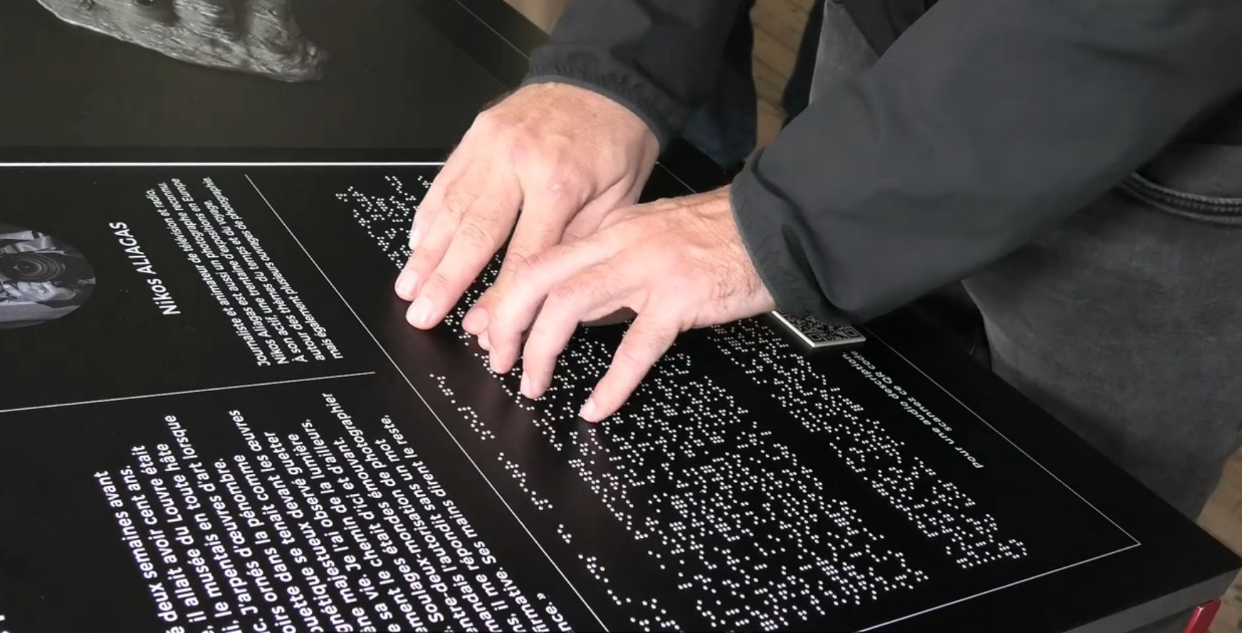 Manos leyendo un panel braille en la conferencia de Coupvray celebrada en 2025 con motivo del bicentenario del nacimiento del Braille
