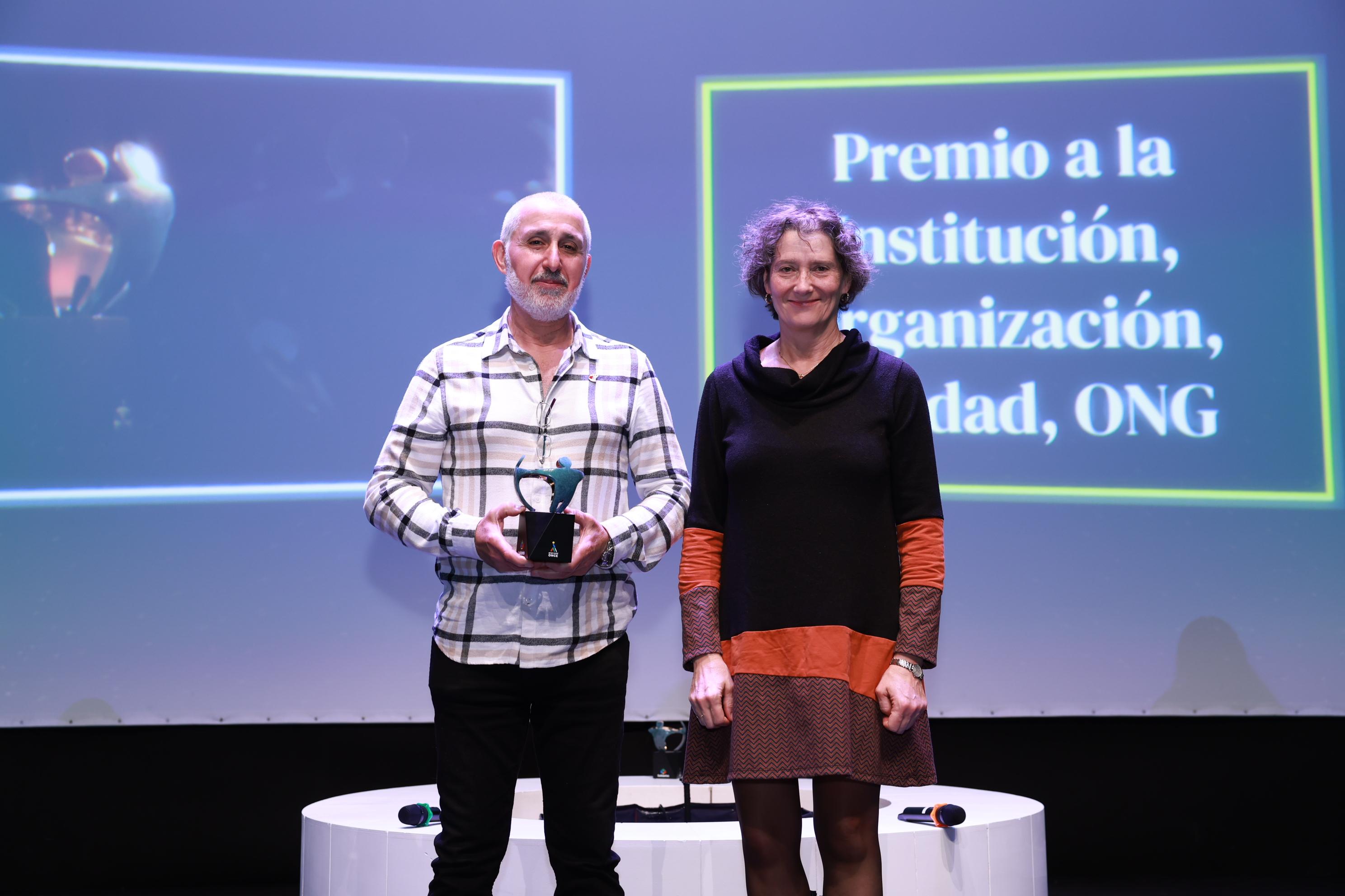 Responsable de ADONA recogiendo el Premio Solidario en el escenario