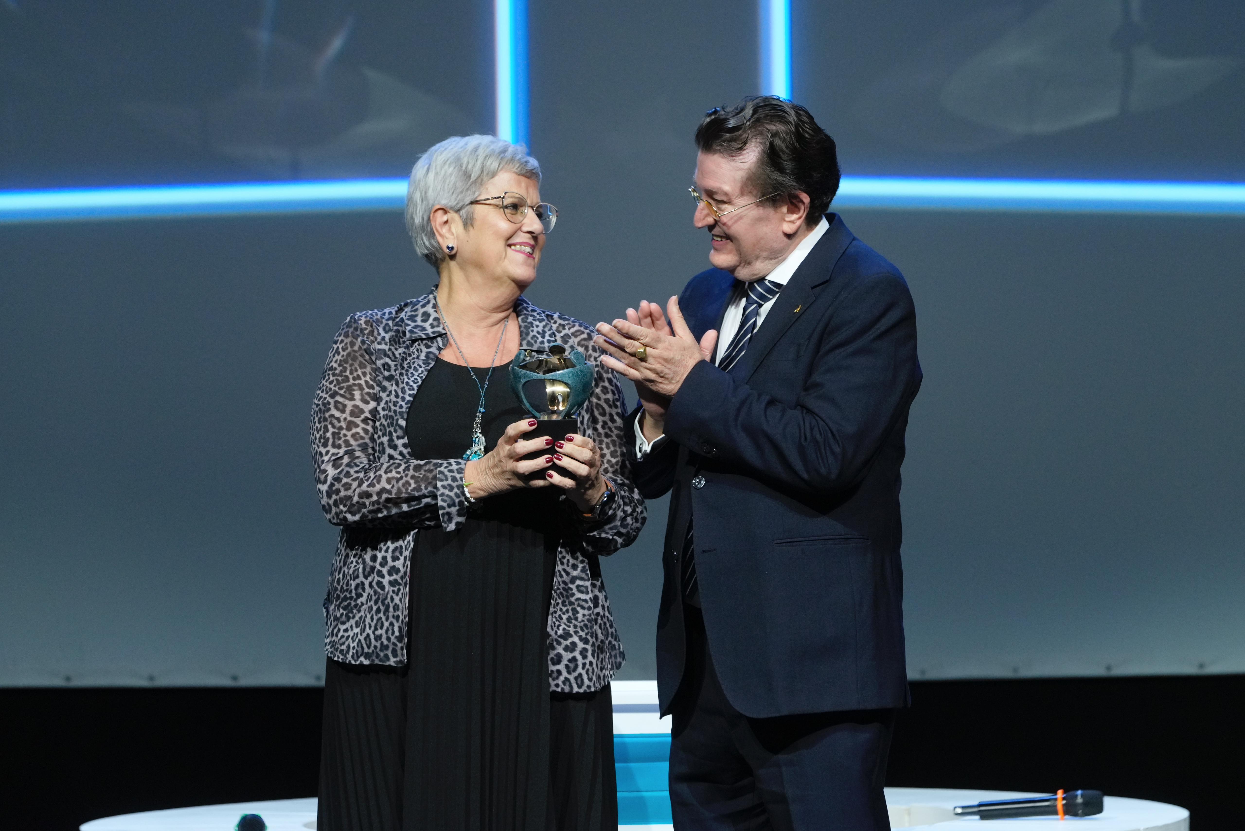 Concepción Martínez Romero ‘Chitina’, recogiendo el Premio Solidario a Persona Física de manos de Ángel Sánchez