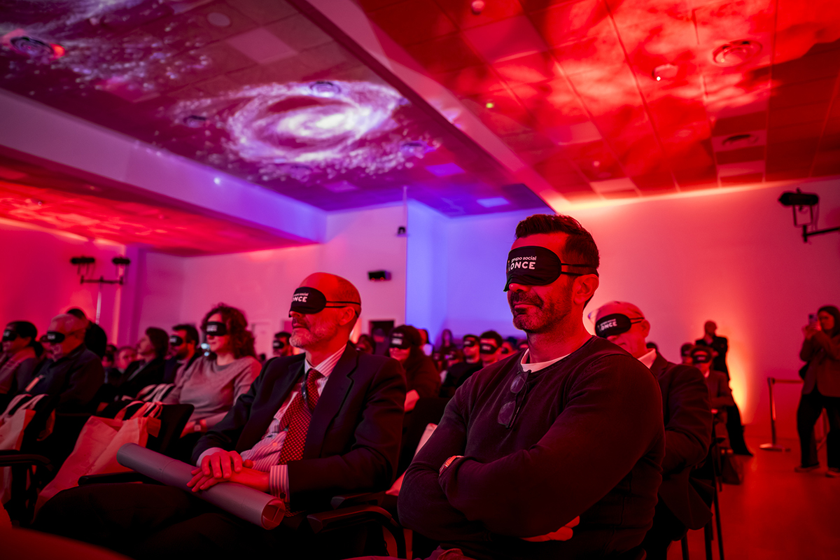 Público con antifaces para conocer la campaña de sensibilización durante el acto