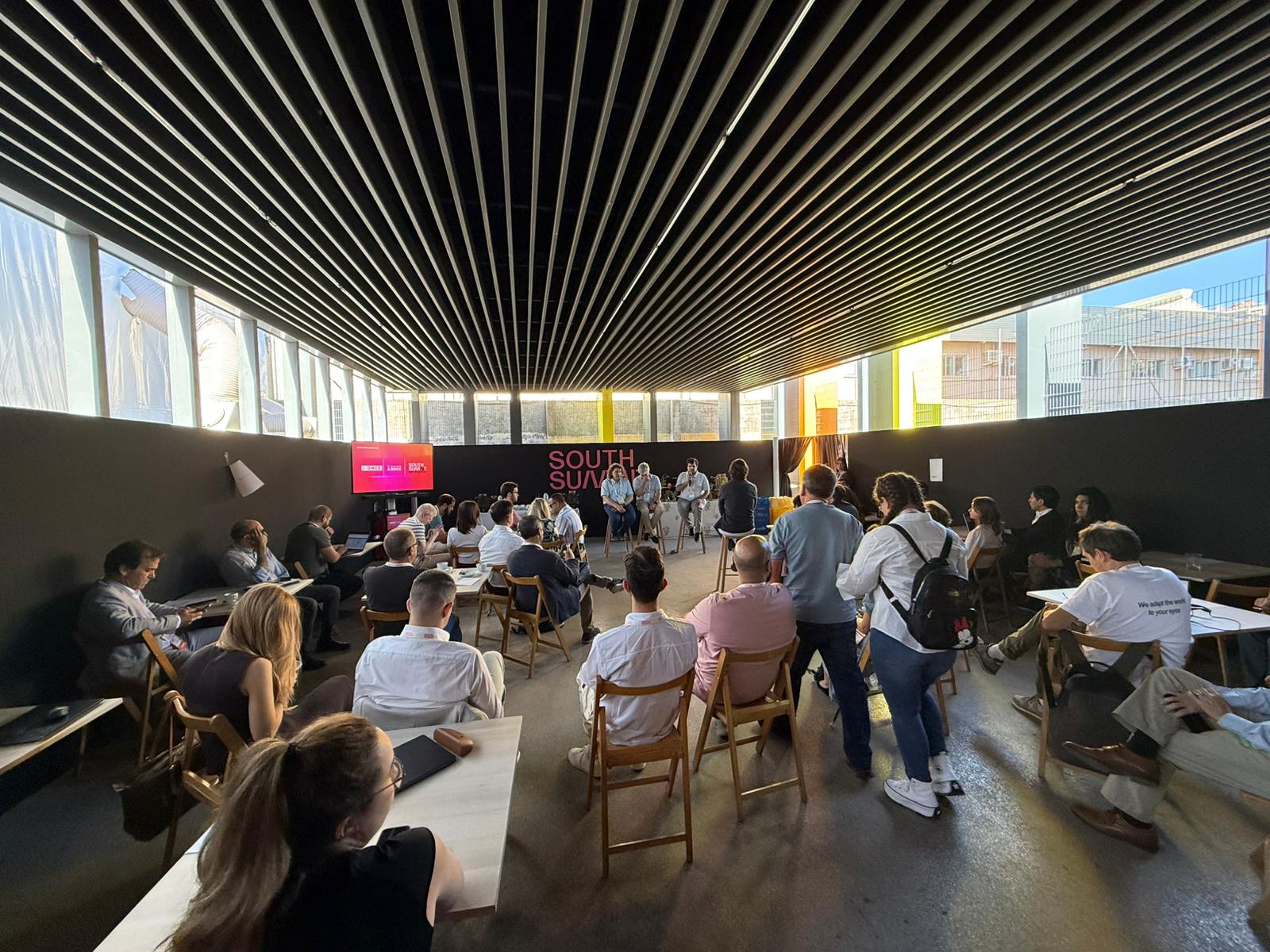 Sesión organizada por ONCE Innova en el espacio Cibeles Square de South Summit. Los asistentes siguen la presentación y el debate sobre los retos de innovación abierta de la organización, en un entorno diseñado para fomentar el diálogo entre startups, profesionales de ONCE y agentes del ecosistema emprendedor.